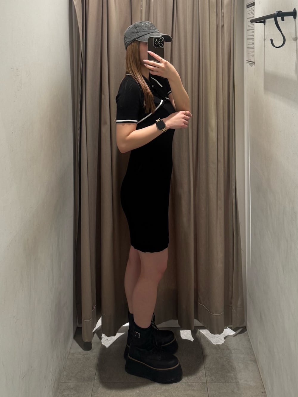 ブラック系のワンピース、ブラック系のブーツを着用したレディースの春コーディネートの2枚目の写真