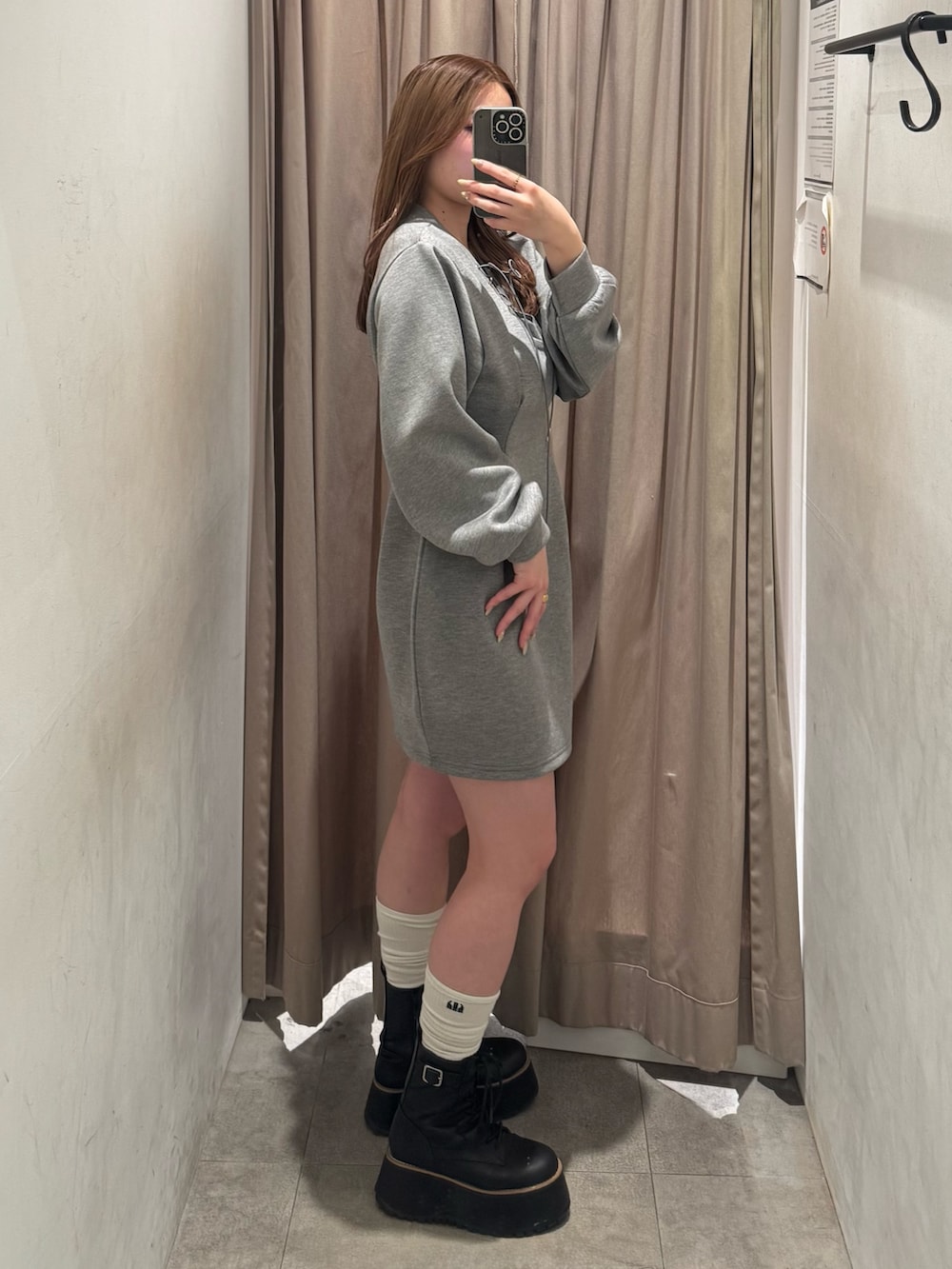 グレー系のワンピース、ブラック系のブーツを着用したレディースの冬コーディネートの2枚目の写真