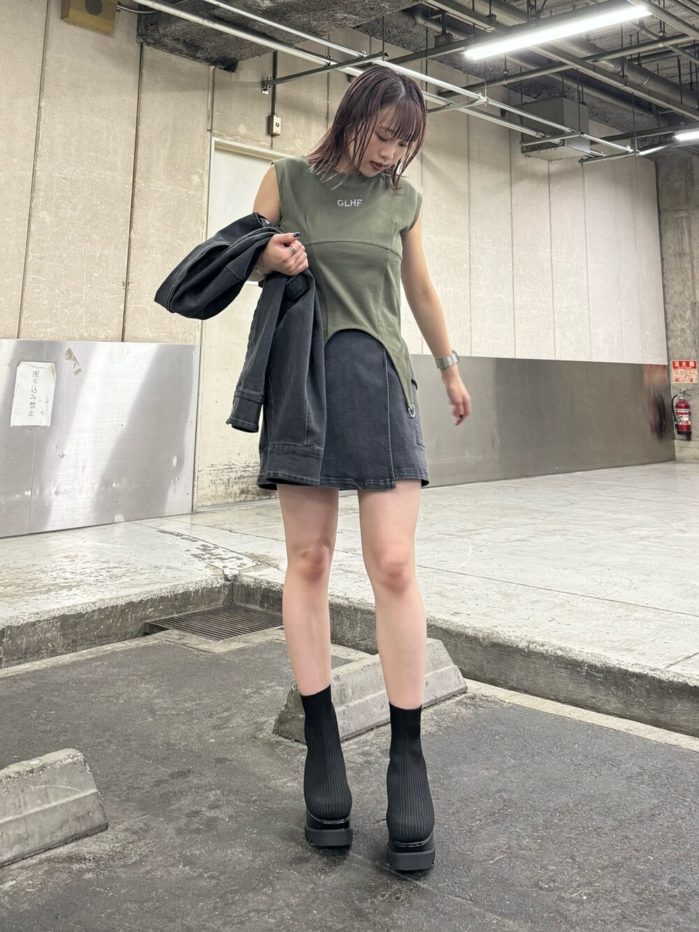 ブラック系のデニムジャケット、ブラック系のスカート、グリーン系のTシャツ/カットソーを着用したレディースの夏コーディネートの5枚目の写真