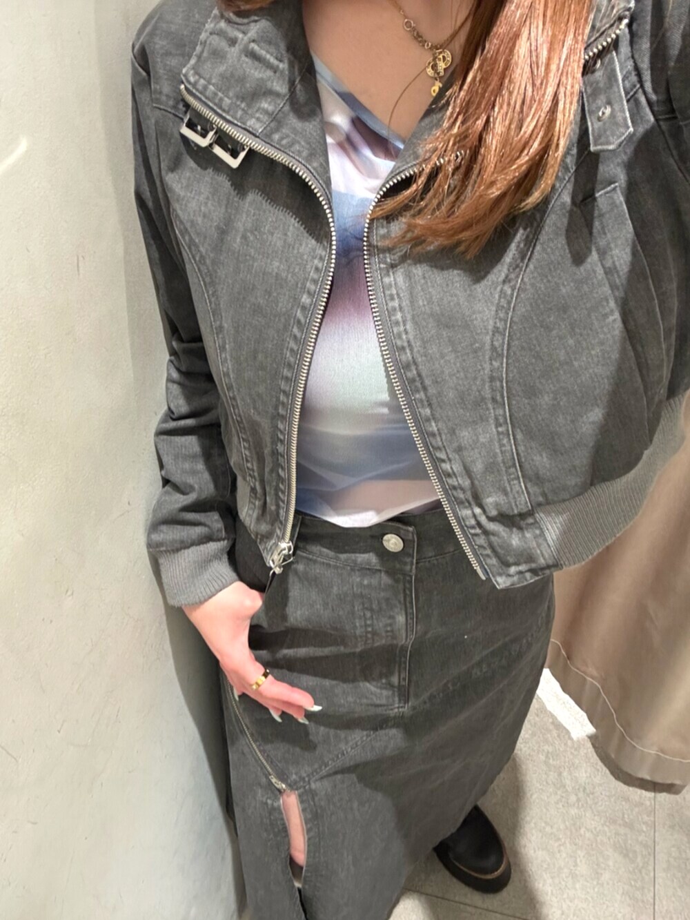 ブラック系のブーツ、グレー系のスカート、グレー系のブルゾンを着用したレディースの春コーディネートの5枚目の写真