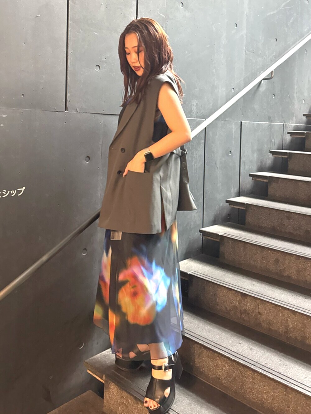 ブラック系のサンダル、グレー系のベスト、ブラック系のワンピースを着用したレディースの夏コーディネートの2枚目の写真