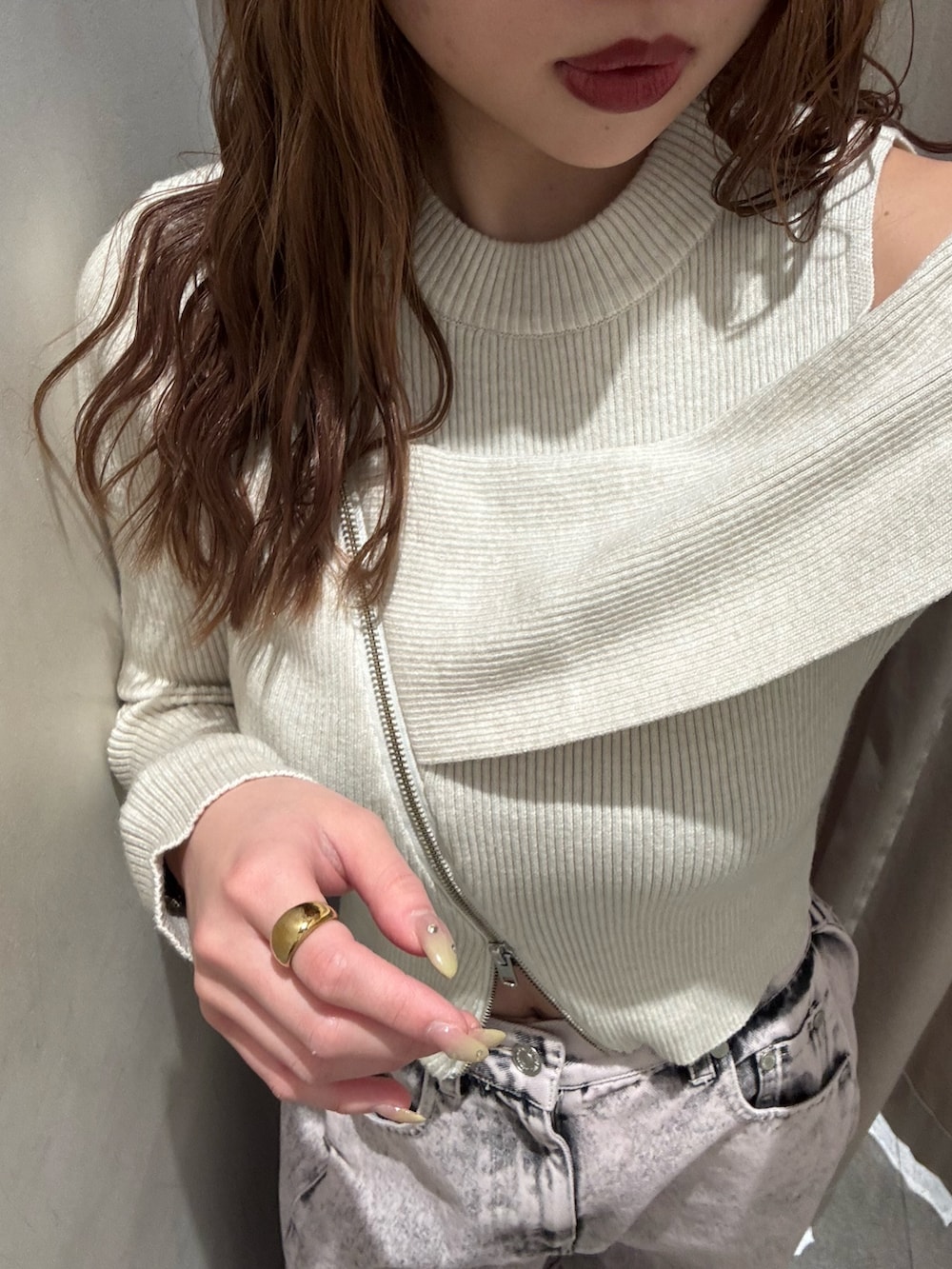 ピンク系のデニムパンツ、ホワイト系のニット/セーター、ブラック系のブーツを着用したレディースの冬コーディネートの5枚目の写真