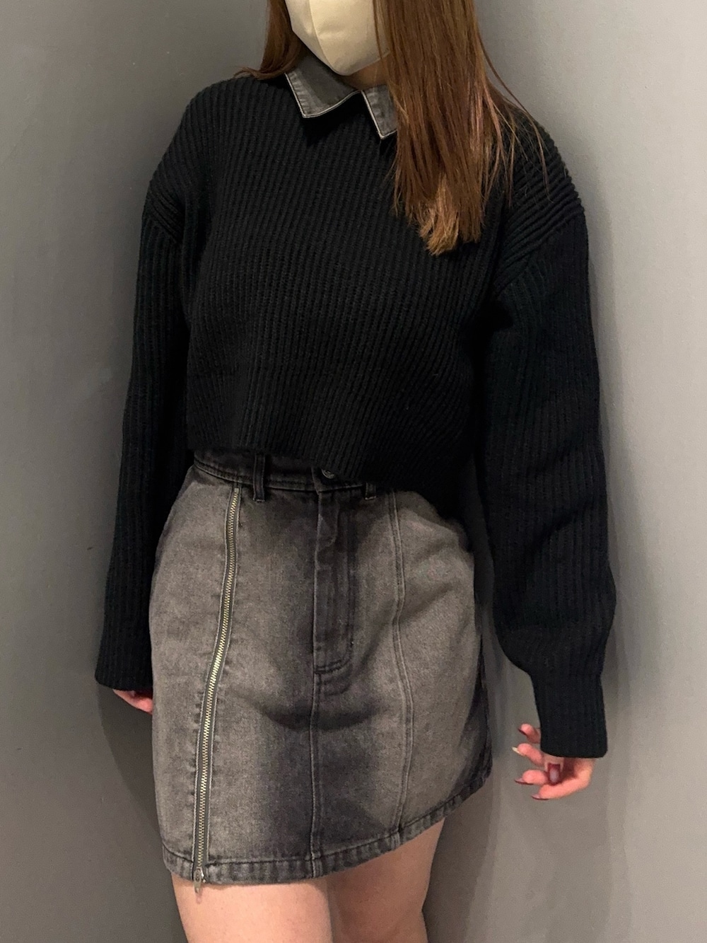 ブラック系のデニムスカート、ブラック系のニット/セーター、ブラック系のブーツを着用したレディースの冬コーディネートの4枚目の写真