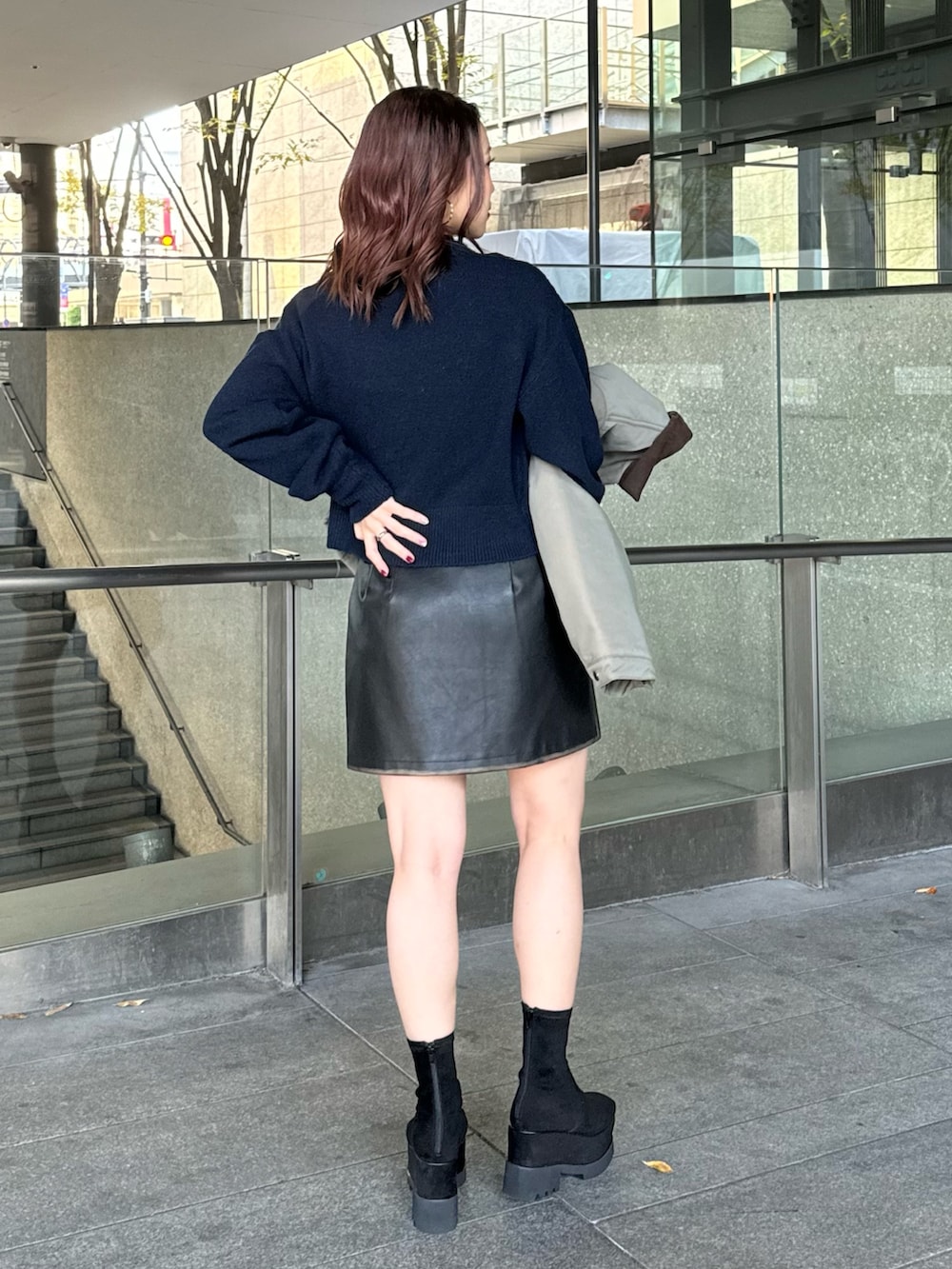 ブルー系のニット/セーター、ブラック系のスカート、ブラック系のブーツを着用したレディースの秋コーディネートの3枚目の写真