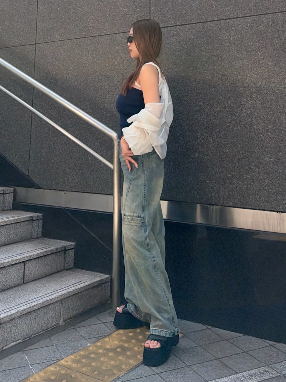 ブルー系のデニムパンツ、ブルー系のタンクトップ、ホワイト系のシャツ/ブラウスを着用したレディースの春コーディネートの2枚目の写真