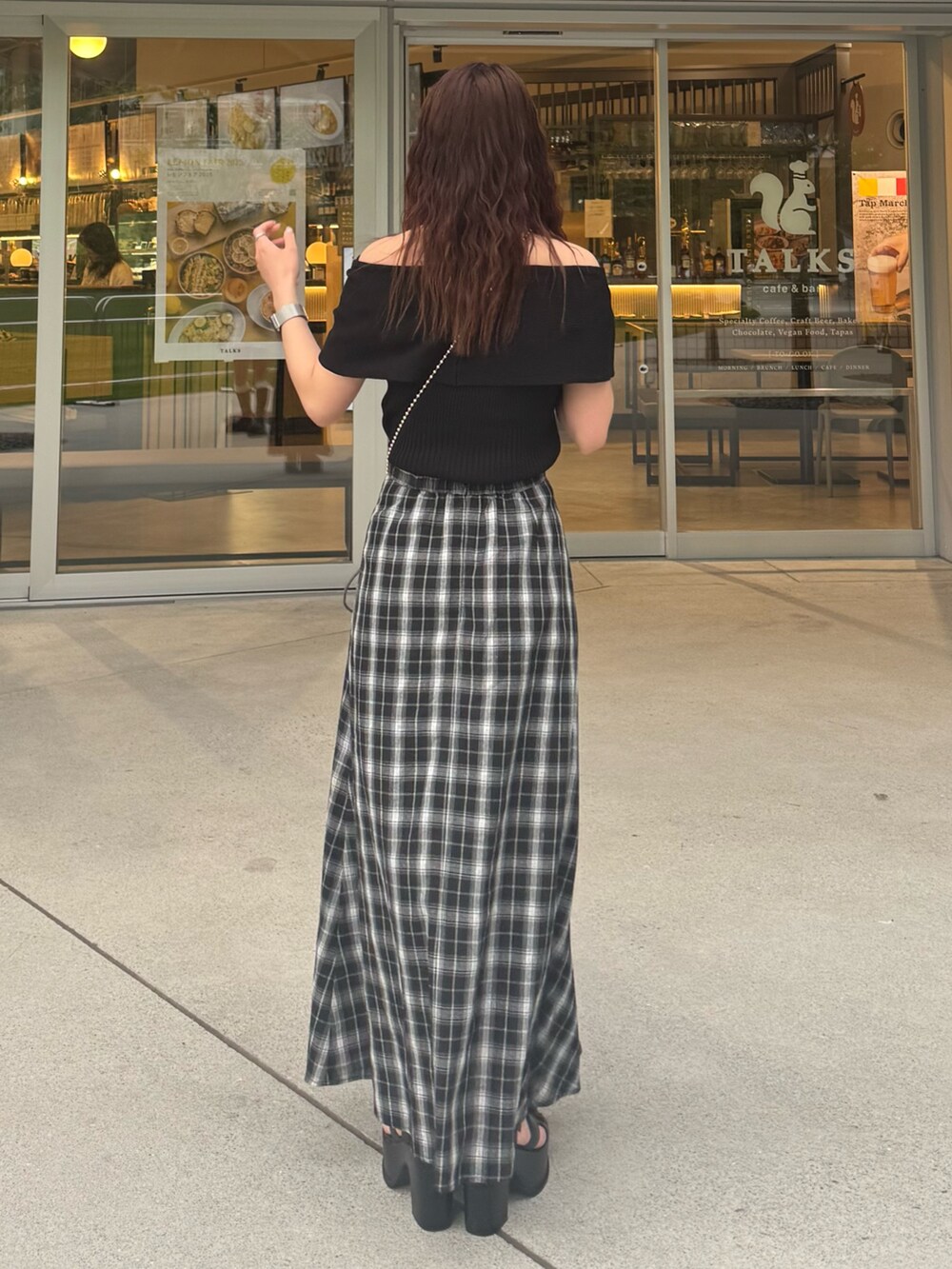 ブラック系のスカート、ブラック系のニット/セーター、ブラック系のサンダルを着用したレディースの夏コーディネートの3枚目の写真