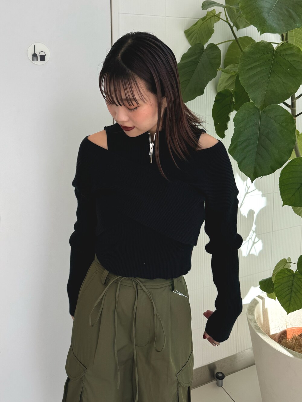 ブラック系のニット/セーター、ベージュ系のカーゴパンツ、ブラウン系のブーツを着用したレディースの秋コーディネートの4枚目の写真