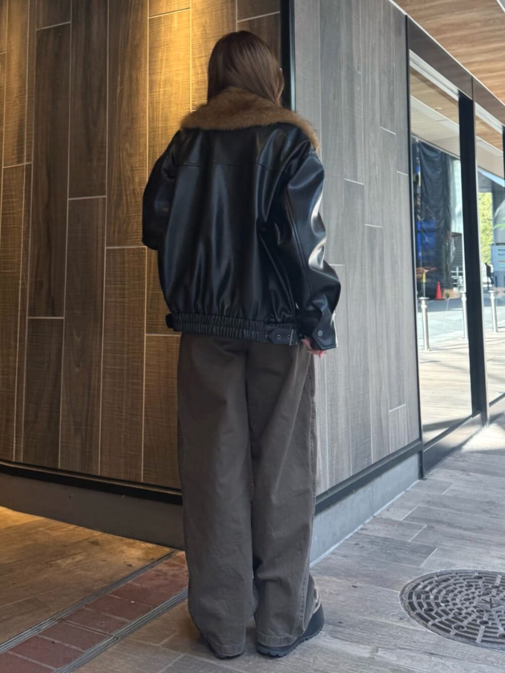 ブラック系のブーツ、ブラック系のブルゾン、ブラウン系のその他パンツを着用したレディースの冬コーディネートの3枚目の写真