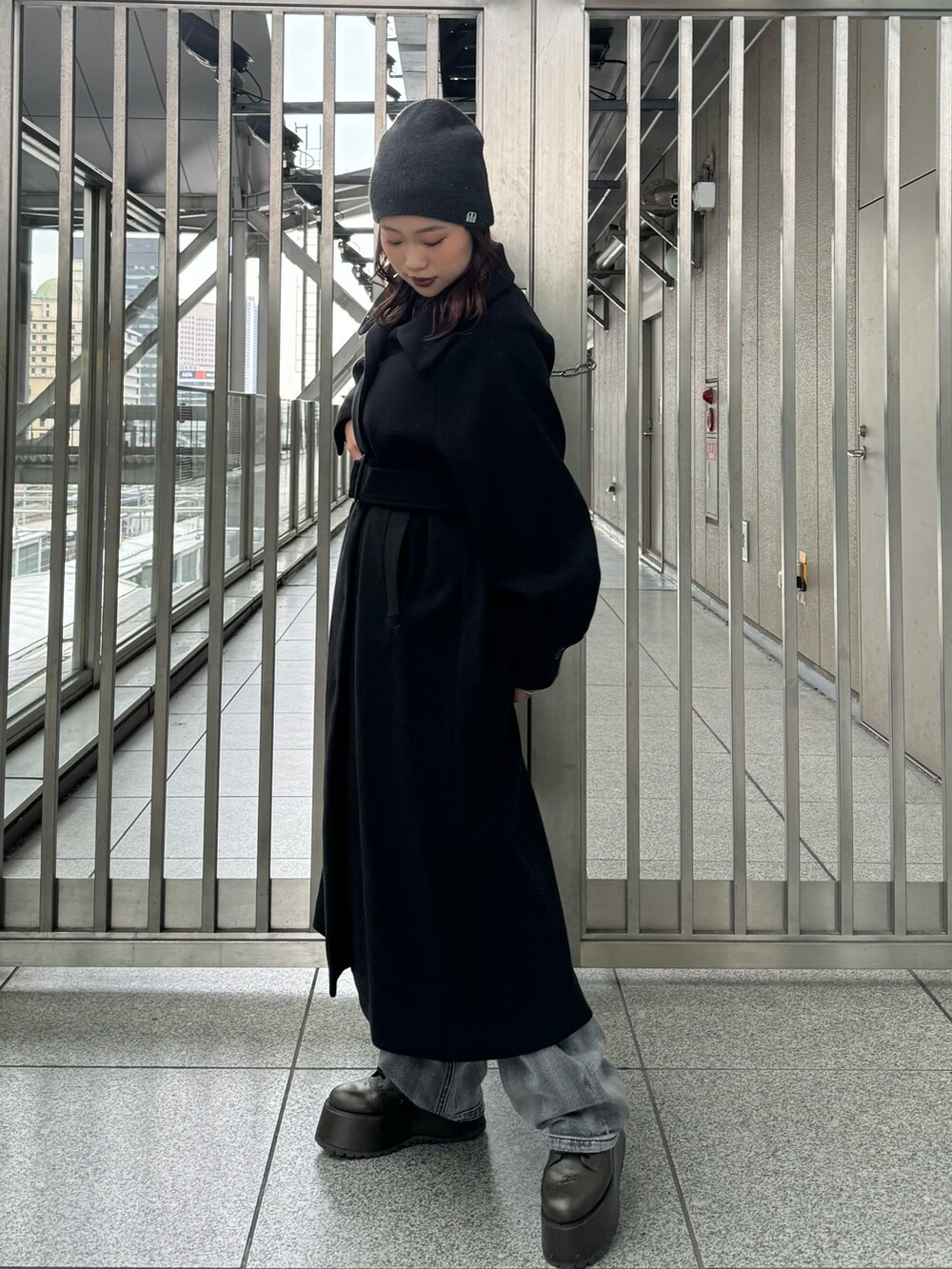 ブラック系のその他アウター、ブラック系のニット/セーター、ブラック系のデニムパンツを着用したレディースの秋コーディネートの2枚目の写真