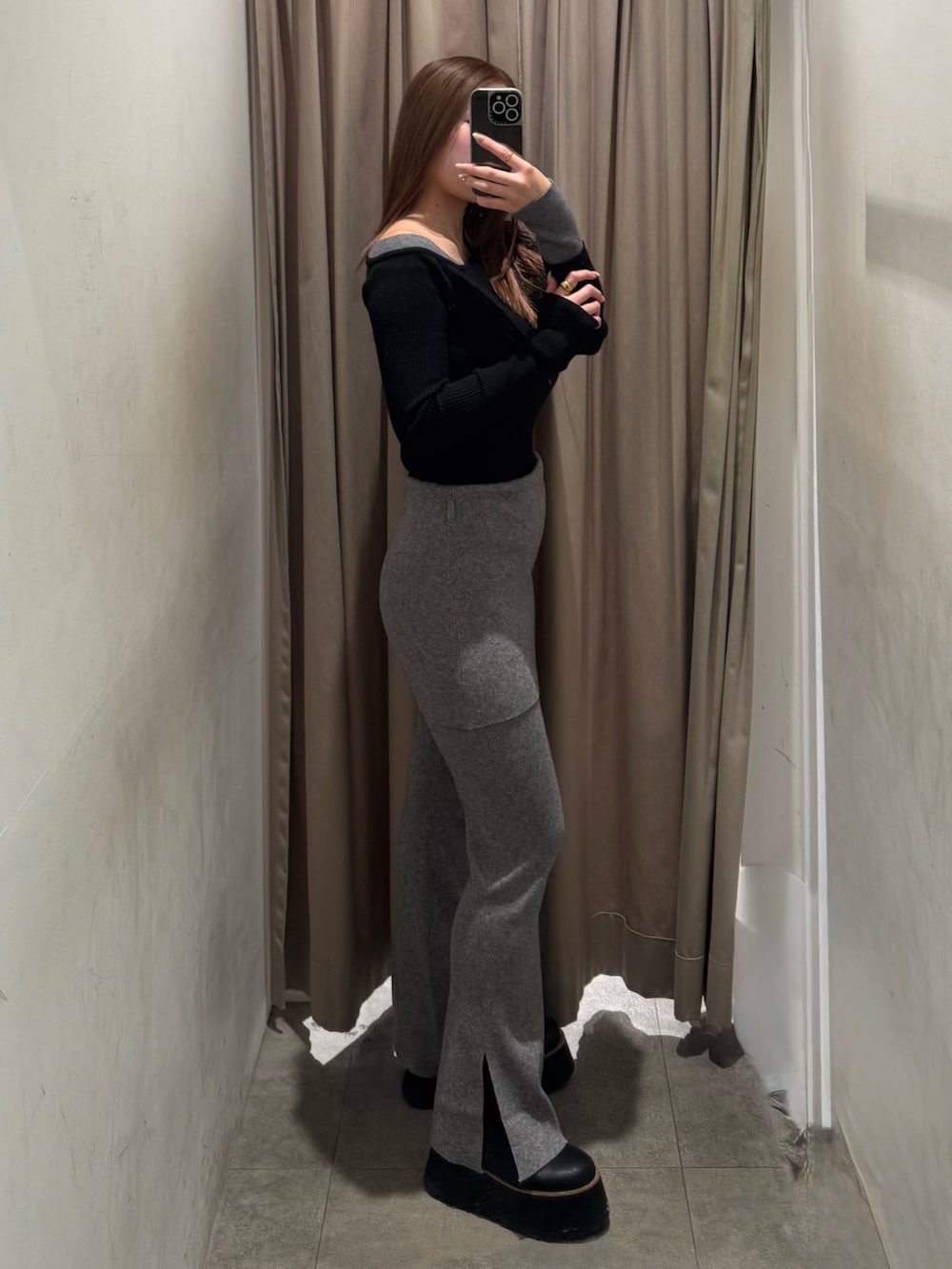 グレー系のその他パンツ、ブラック系のニット/セーター、ブラック系のブーツを着用したレディースの冬コーディネートの2枚目の写真