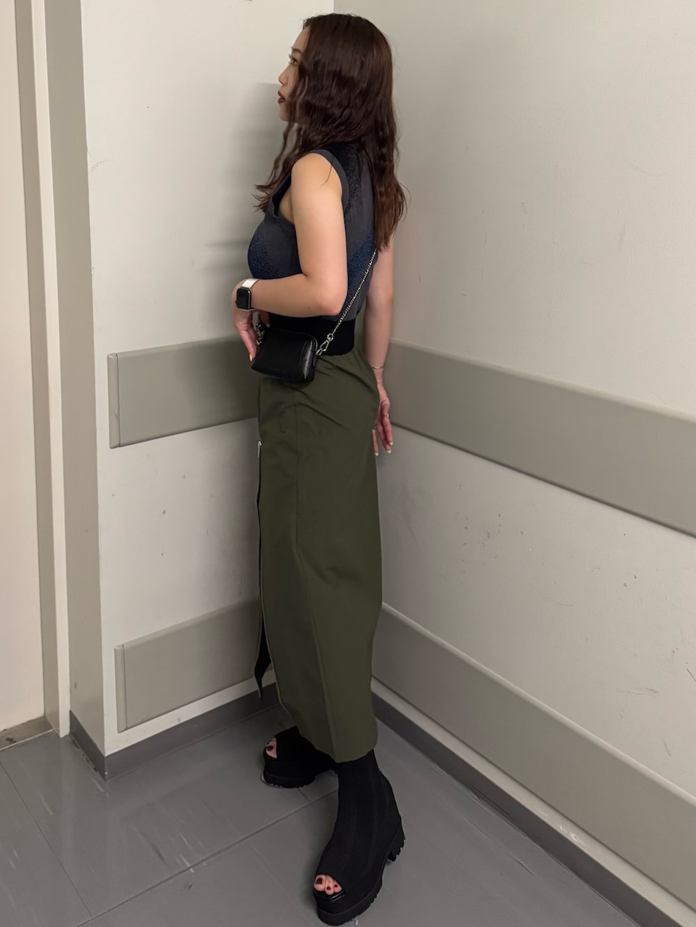 ブラック系のタンクトップ、グリーン系のスカート、ブラック系のサンダルを着用したレディースの夏コーディネートの2枚目の写真