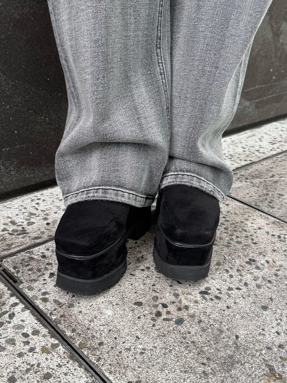 レッド系のニット/セーター、ブラック系のデニムパンツ、ブラック系のブーツを着用したレディースの冬コーディネートの7枚目の写真