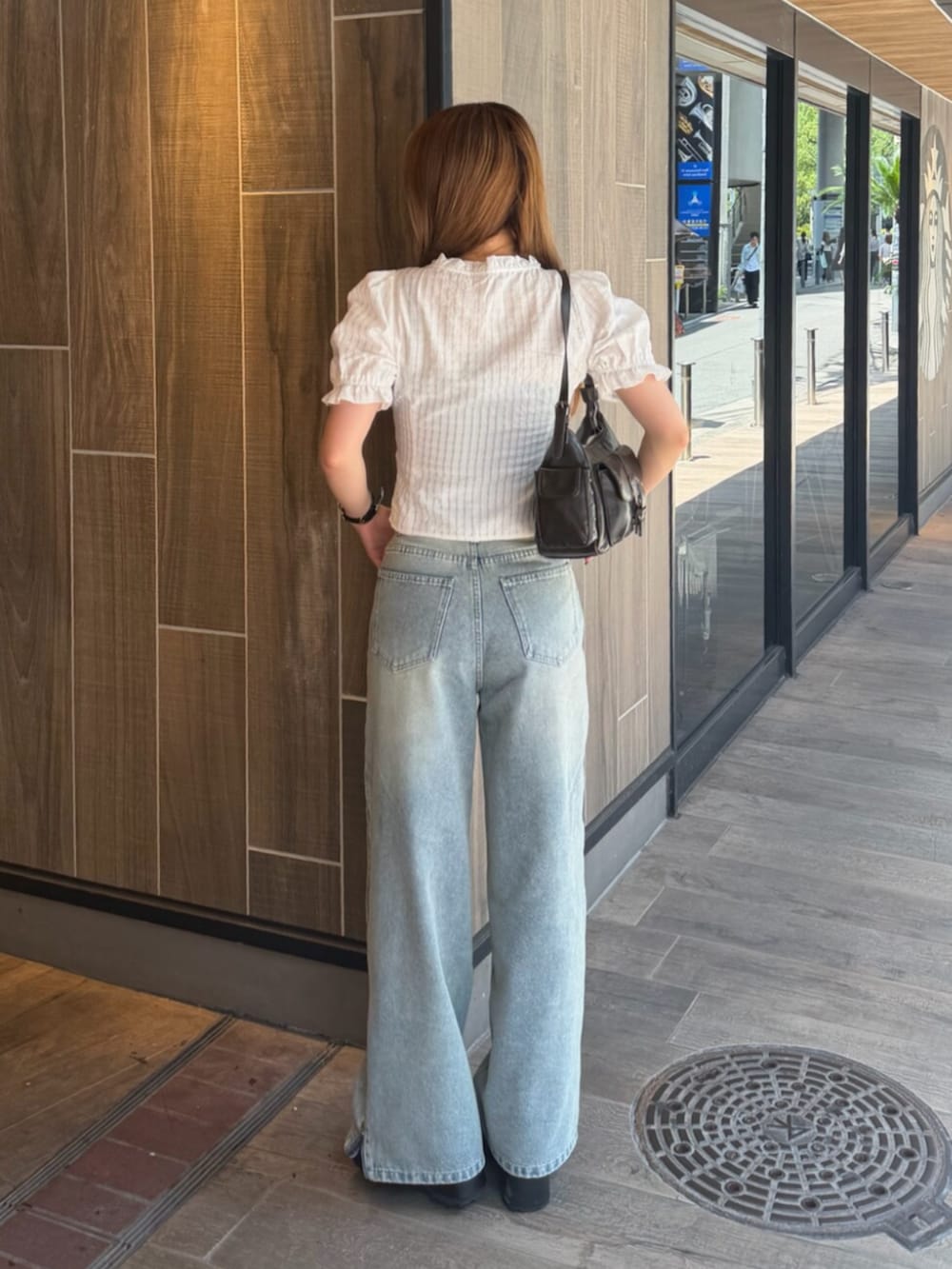 ブラック系のブーツ、ブルー系のデニムパンツ、ホワイト系のシャツ/ブラウスを着用したレディースの夏コーディネートの3枚目の写真