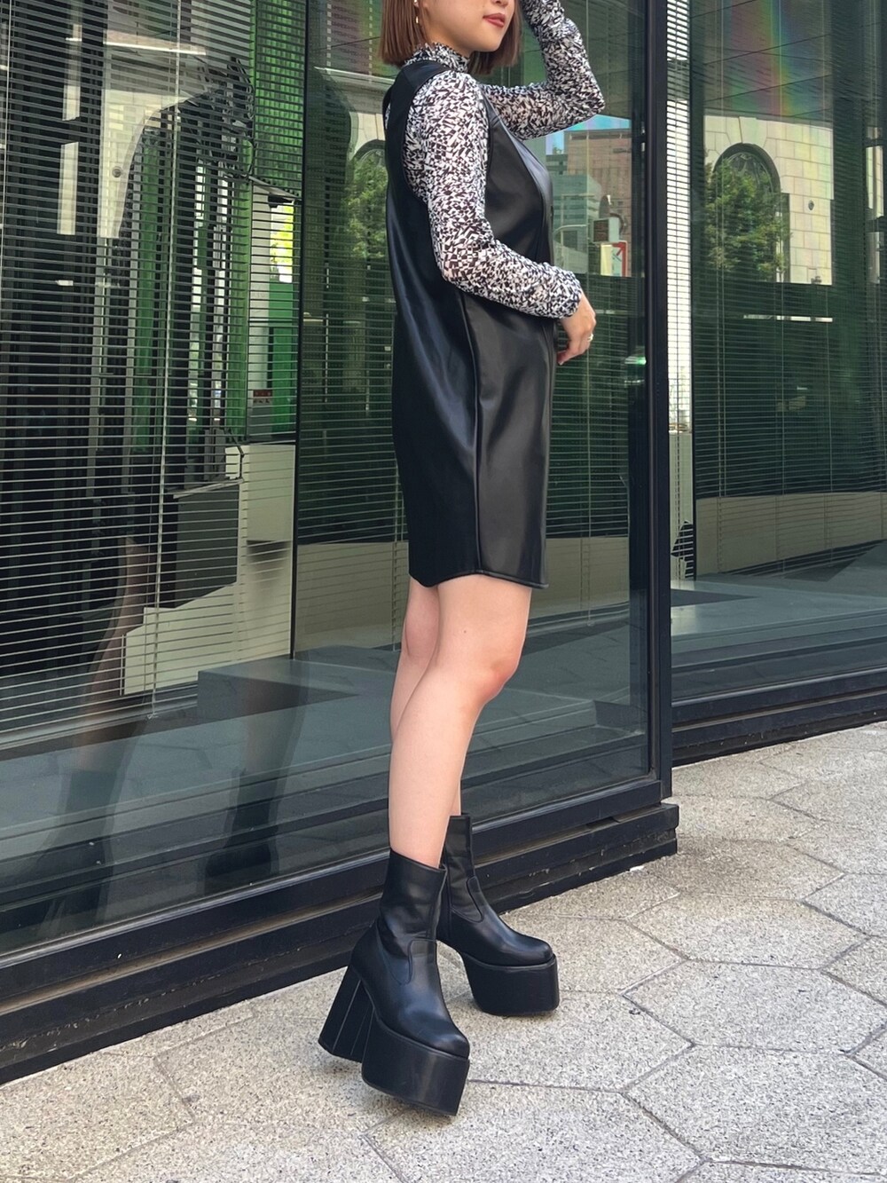 ホワイト系のTシャツ/カットソー、ブラック系のワンピース、ブラック系のブーツを着用したレディースの夏コーディネートの3枚目の写真
