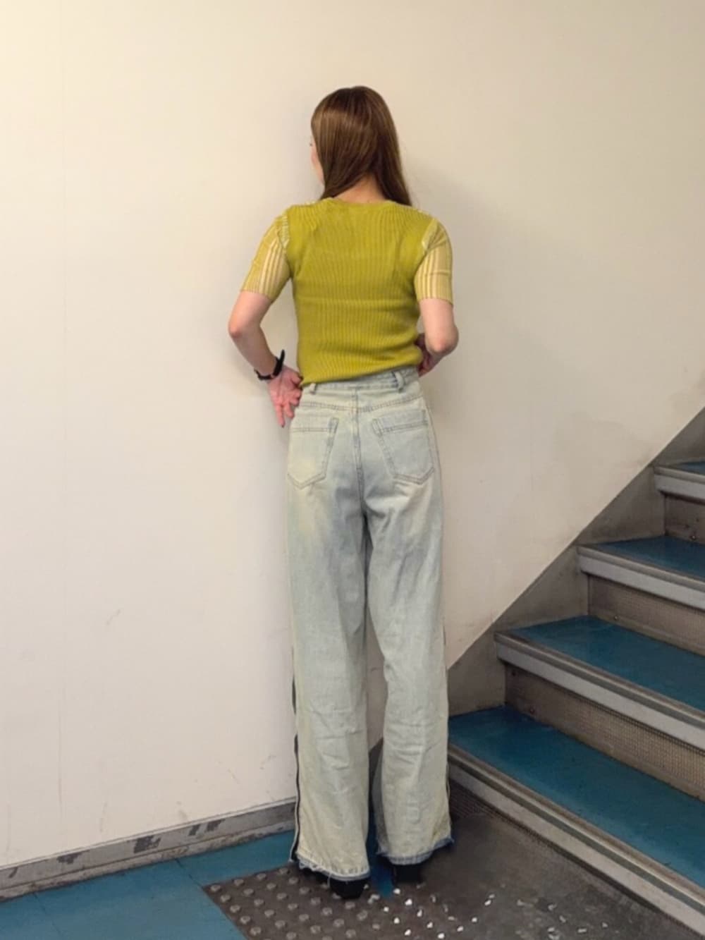 ブラック系のブーツ、ブルー系のデニムパンツ、グリーン系のニット/セーターを着用したレディースの夏コーディネートの3枚目の写真