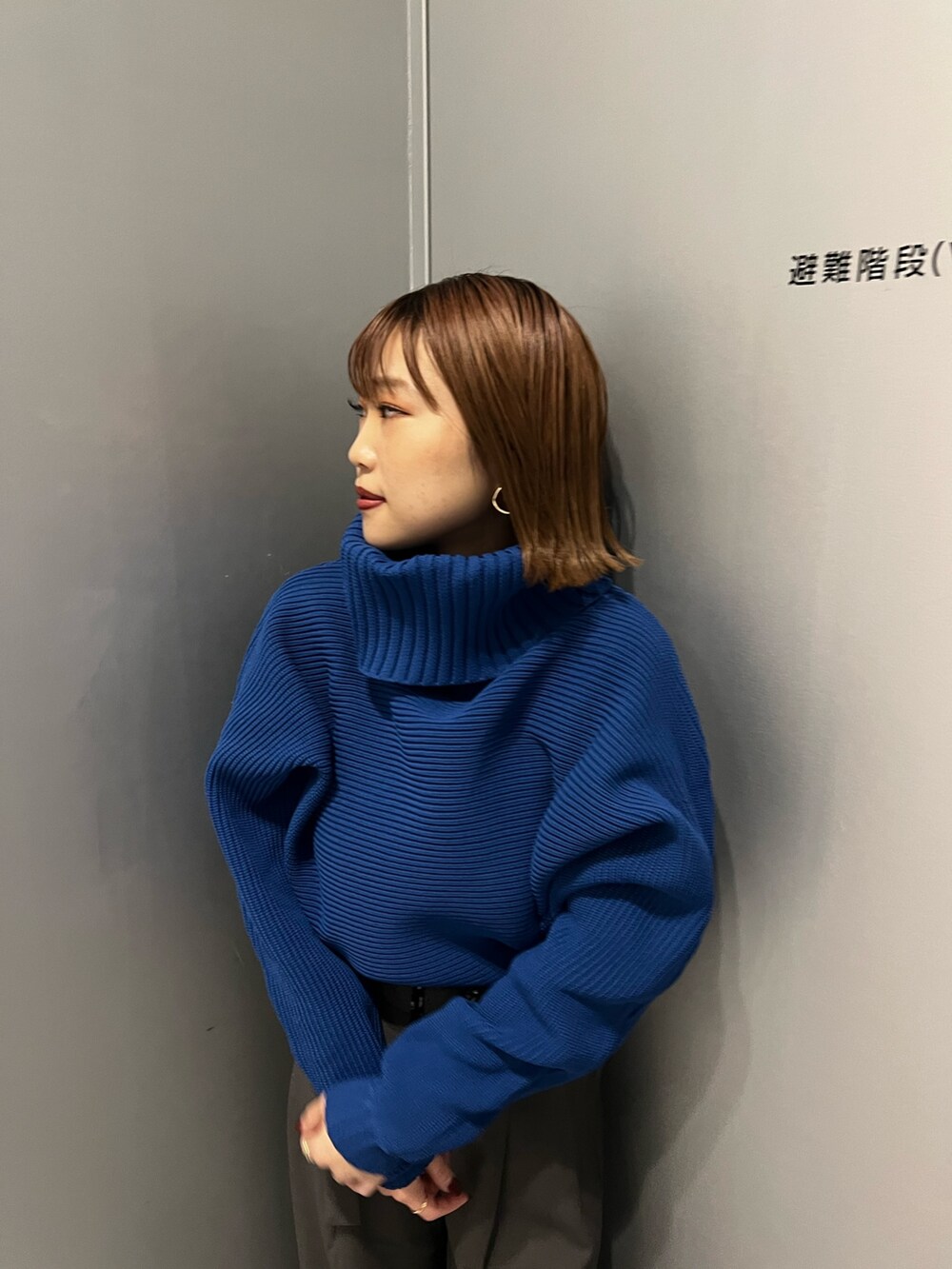 ブルー系のニット/セーター、グレー系のその他パンツを着用したレディースの秋コーディネートの4枚目の写真