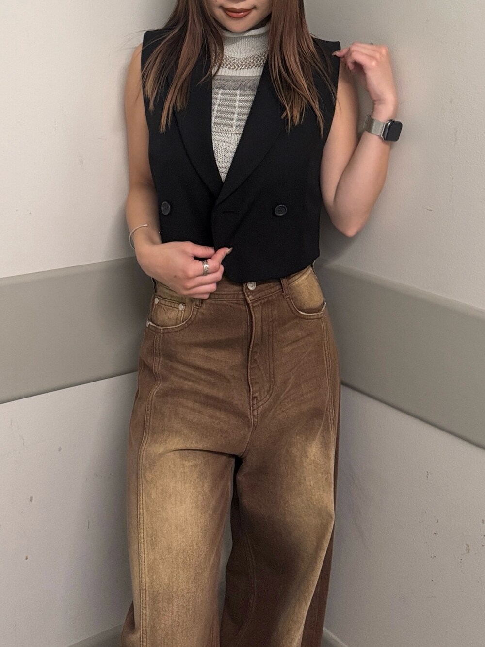 ブラウン系のデニムパンツ、グレー系のタンクトップ、ブラック系のベストを着用したレディースの夏コーディネートの4枚目の写真