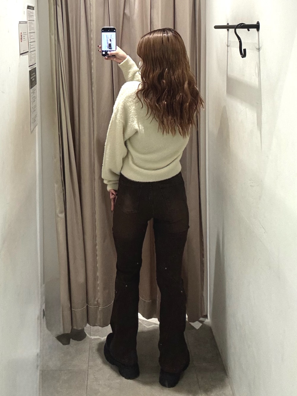 ホワイト系のニット/セーター、ブラウン系のデニムパンツ、ブラック系のブーツを着用したレディースの秋コーディネートの3枚目の写真