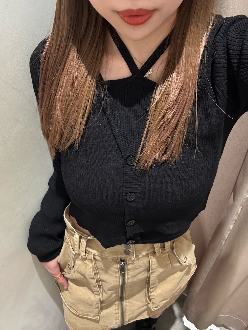 ベージュ系のスカート、ブラック系のニット/セーター、ブラック系のブーツを着用したレディースの春コーディネートの5枚目の写真