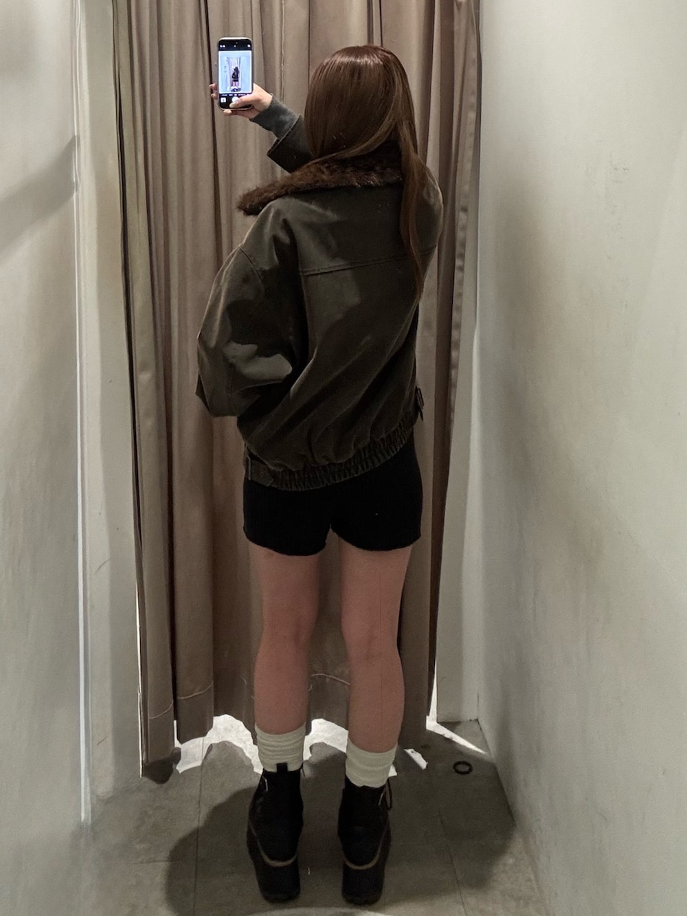 ブラウン系のブルゾン、ブラック系のその他パンツ、ブラック系のブーツを着用したレディースの冬コーディネートの3枚目の写真