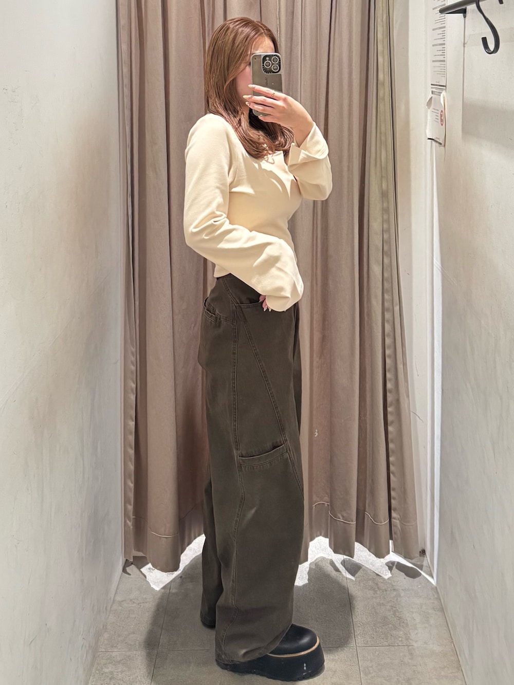 ブラウン系のその他パンツ、ホワイト系のTシャツ/カットソー、ブラック系のブーツを着用したレディースの冬コーディネートの2枚目の写真