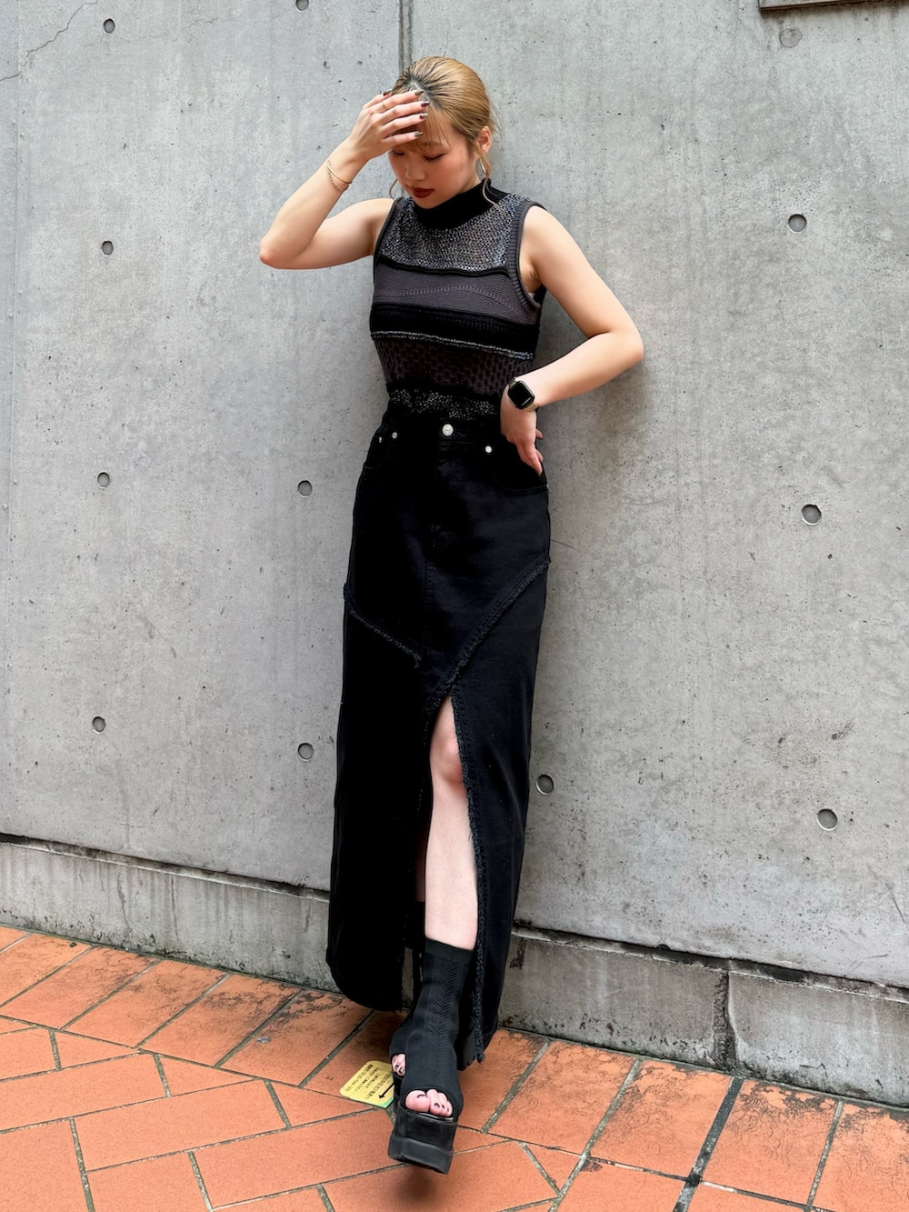 ブラック系のニット/セーター、ブラック系のデニムスカートを着用したレディースの夏コーディネートの2枚目の写真