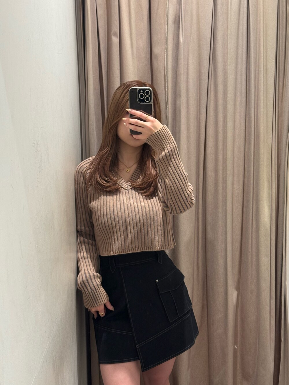 ブラック系のスカート、ベージュ系のニット/セーター、ブラック系のブーツを着用したレディースの冬コーディネートの4枚目の写真