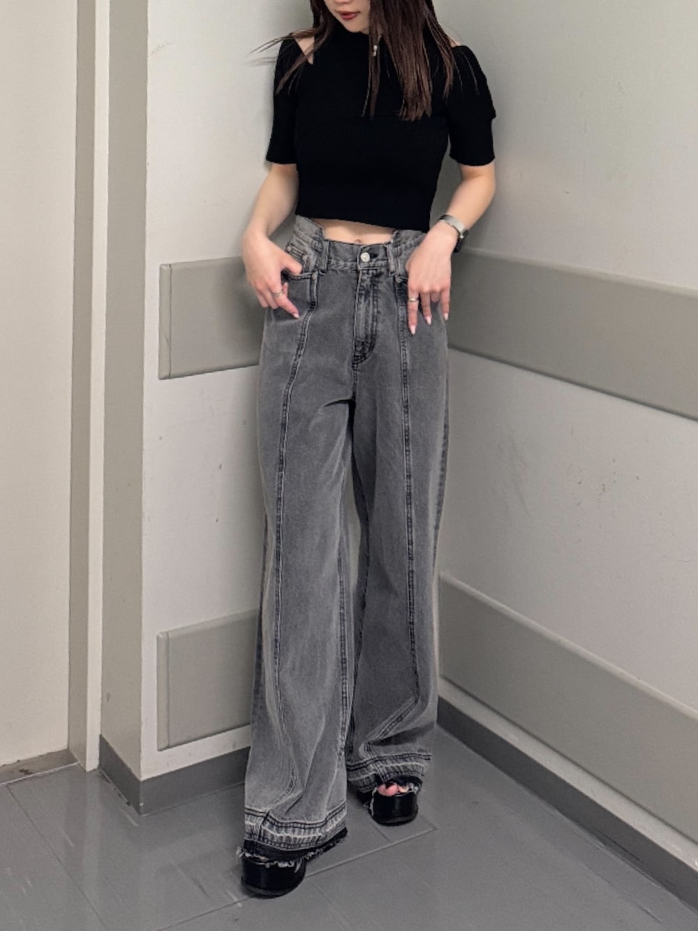 ブラック系のデニムパンツ、ブラック系のニット/セーター、ブラック系のサンダルを着用したレディースの春コーディネートの5枚目の写真