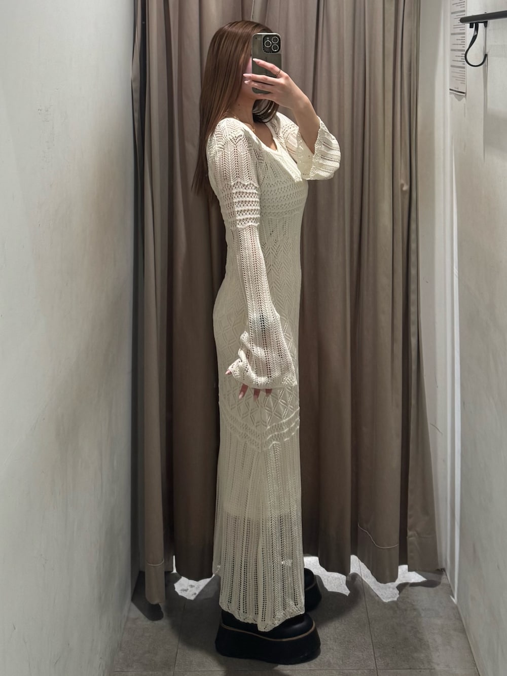 ホワイト系のワンピース、ブラック系のブーツを着用したレディースの春コーディネートの2枚目の写真