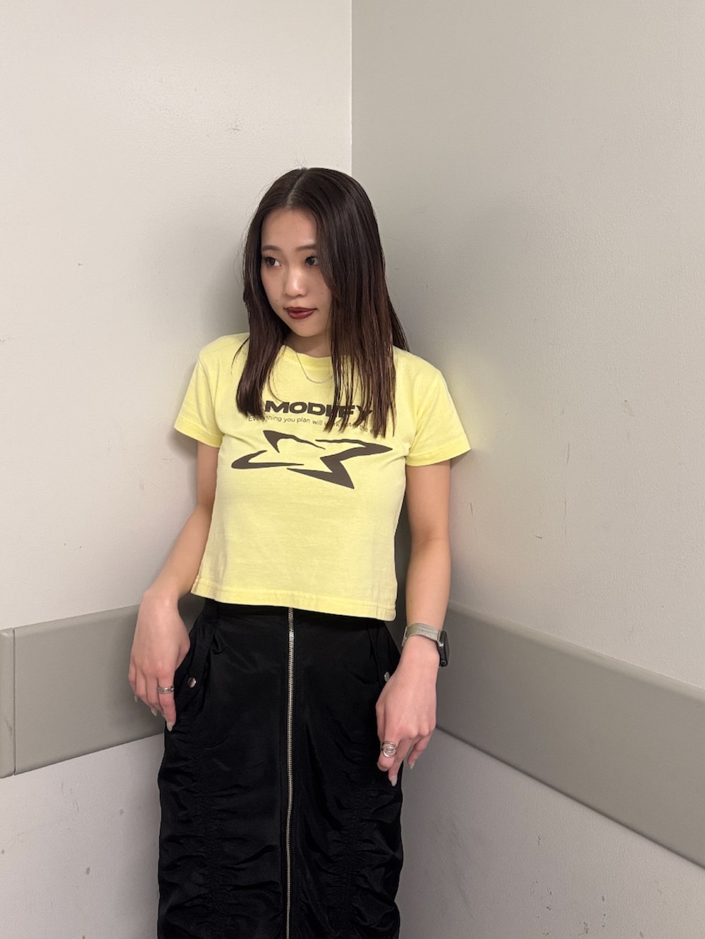 イエロー系のTシャツ/カットソー、ブラック系のスカート、ブラック系のブーツを着用したレディースの春コーディネートの4枚目の写真