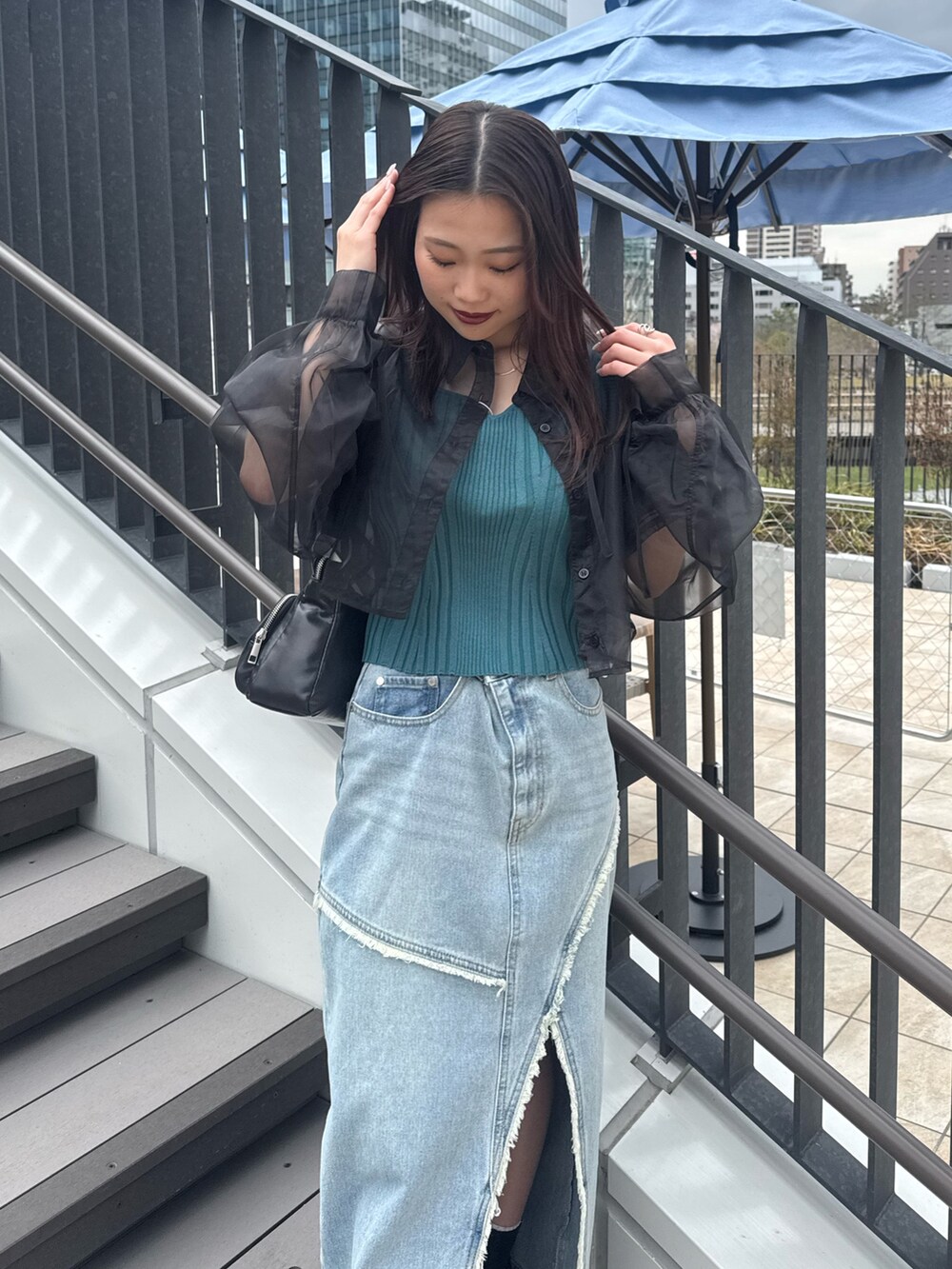 ブルー系のデニムスカート、ブラック系のシャツ/ブラウス、ブルー系のタンクトップを着用したレディースの春コーディネートの4枚目の写真