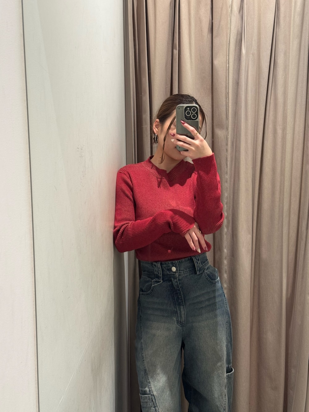 ブルー系のデニムパンツ、レッド系のニット/セーター、ブラック系のブーツを着用したレディースの冬コーディネートの4枚目の写真