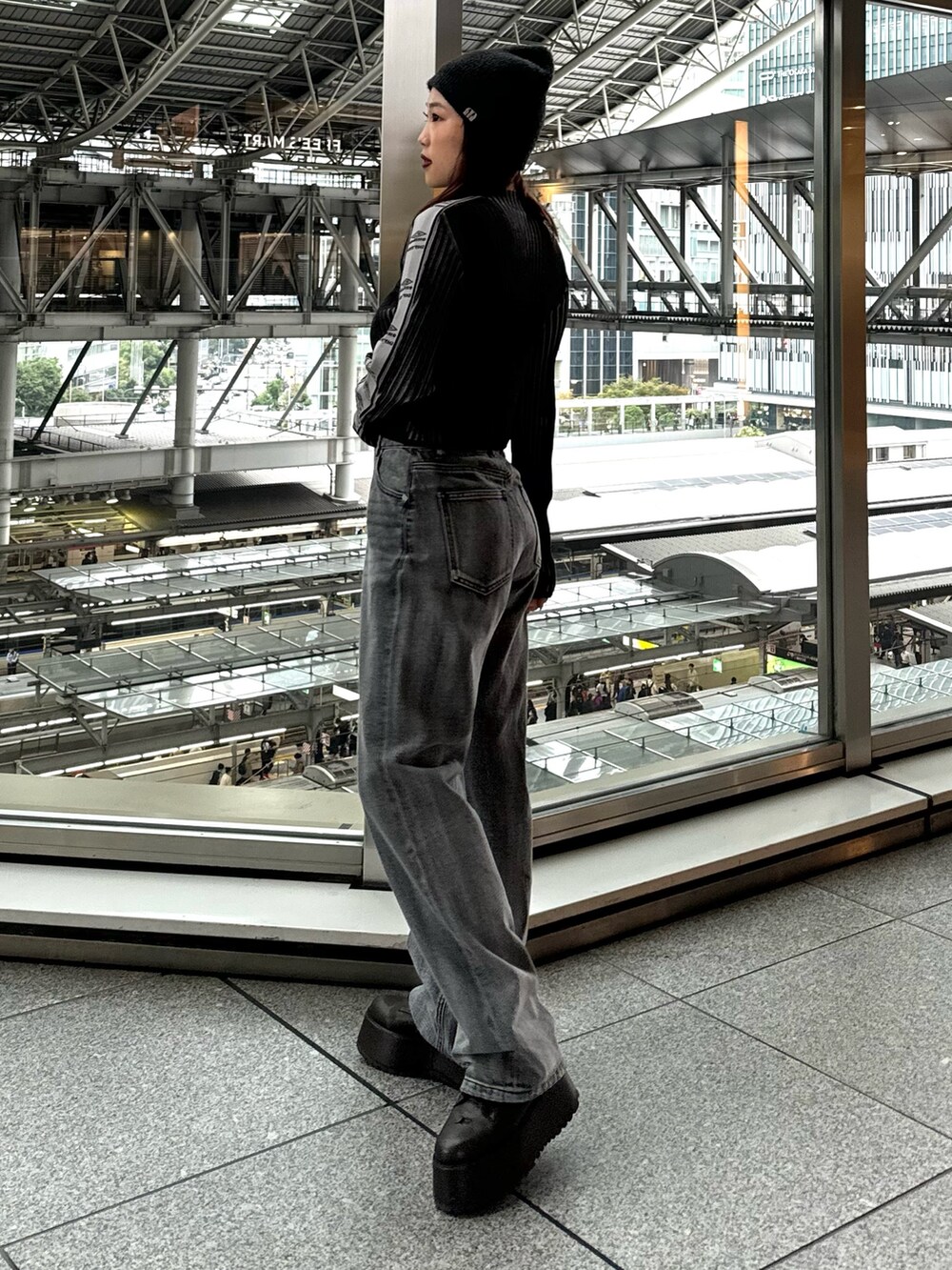 ブラック系のニット/セーター、ブラック系のデニムパンツ、ブラウン系のブーツを着用したレディースの秋コーディネートの3枚目の写真