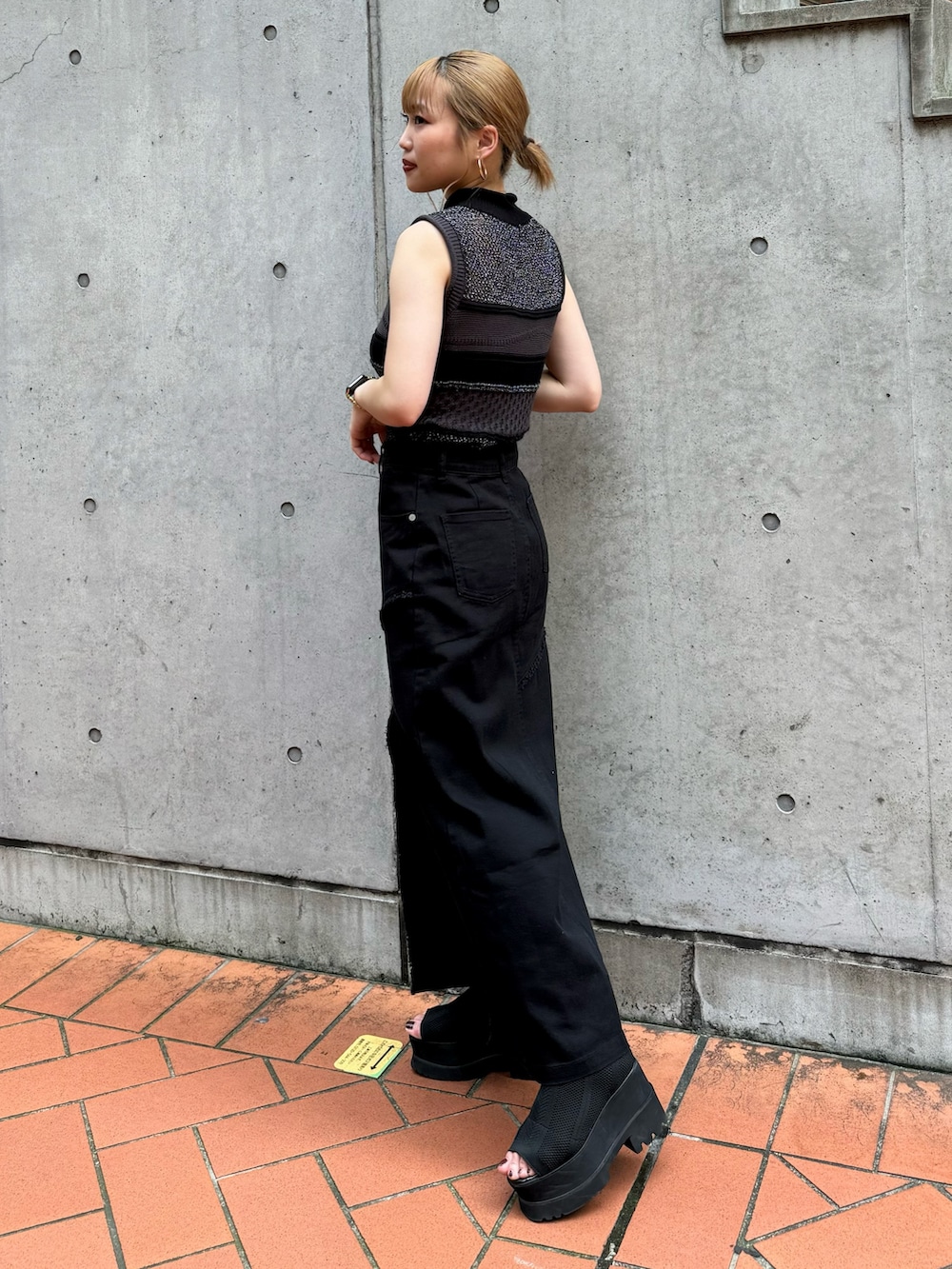 ブラック系のニット/セーター、ブラック系のデニムスカートを着用したレディースの夏コーディネートの3枚目の写真