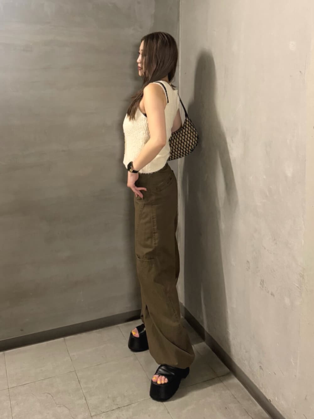 ブラック系のブーツ、ブラウン系のその他パンツ、ホワイト系のタンクトップを着用したレディースの夏コーディネートの2枚目の写真