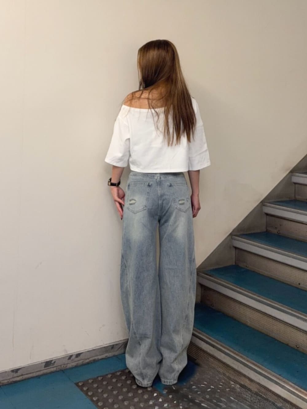 ブルー系のデニムパンツ、ブラック系のブーツ、ホワイト系のTシャツ/カットソーを着用したレディースの夏コーディネートの3枚目の写真