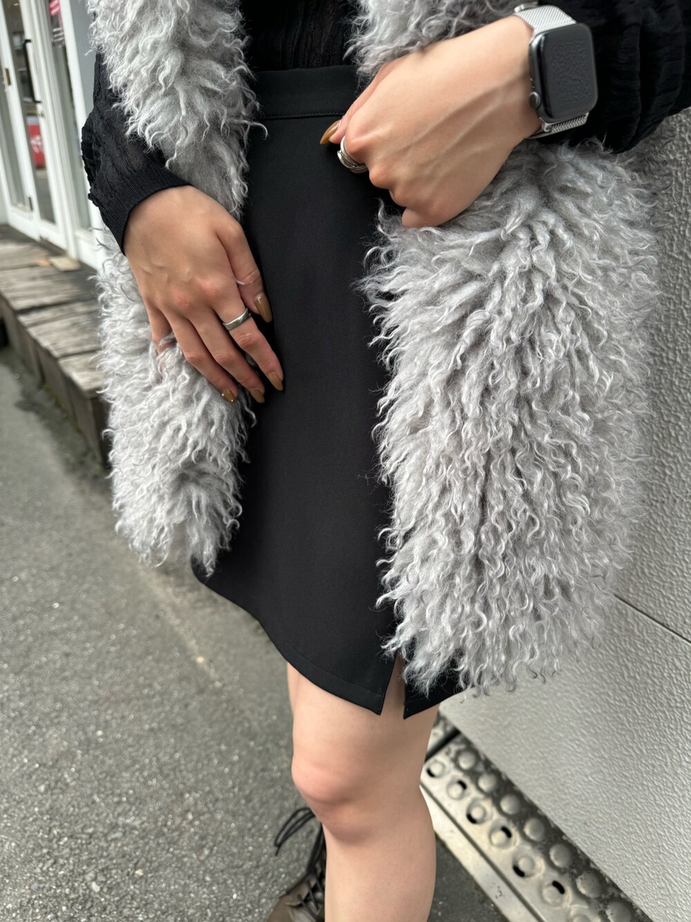 ブラック系のニット/セーター、グレー系のベスト、ブラック系のスカートを着用したレディースの秋コーディネートの7枚目の写真