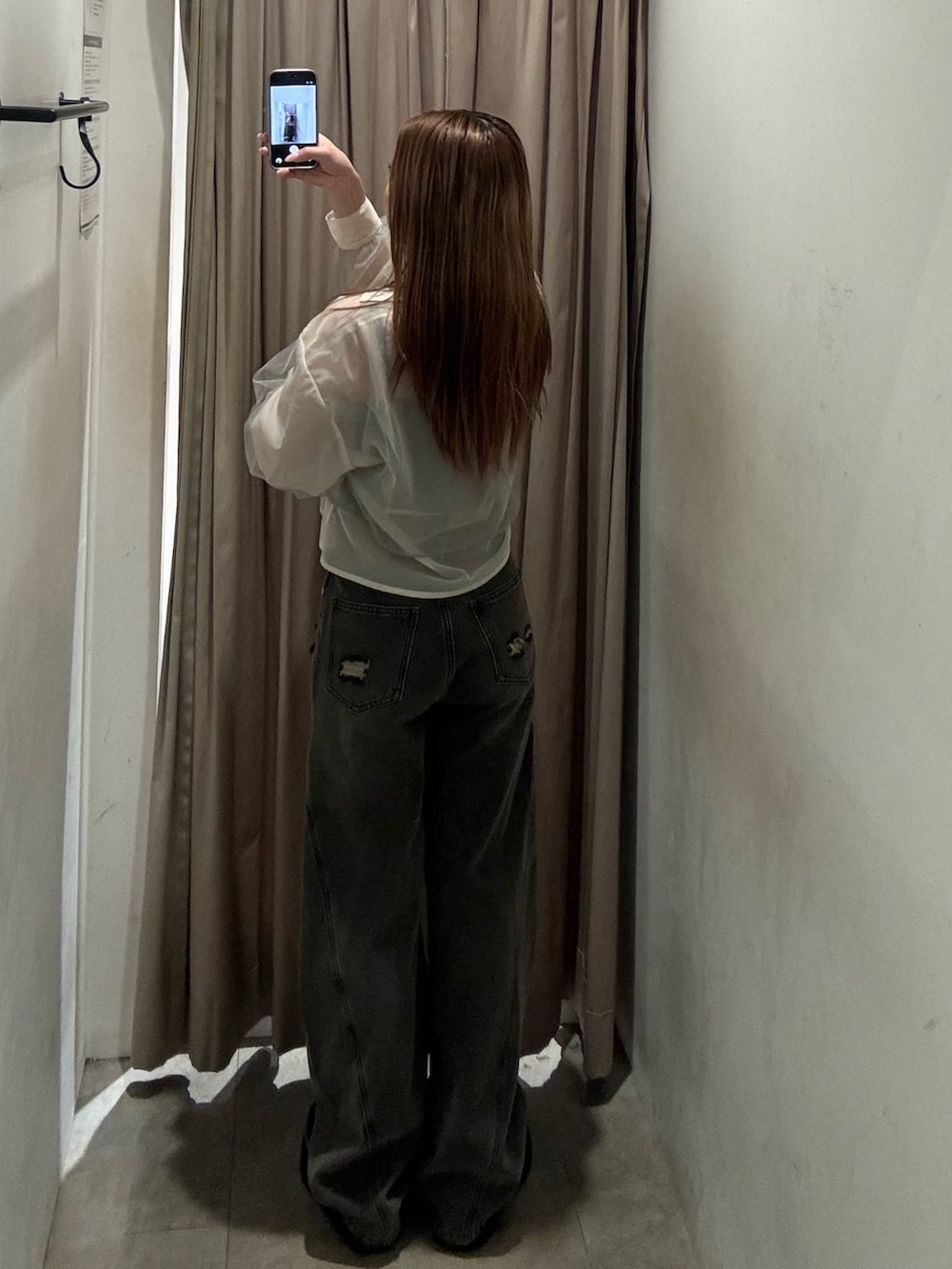 グレー系のデニムパンツ、イエロー系のシャツ/ブラウス、ブラック系のブーツを着用したレディースの春コーディネートの3枚目の写真