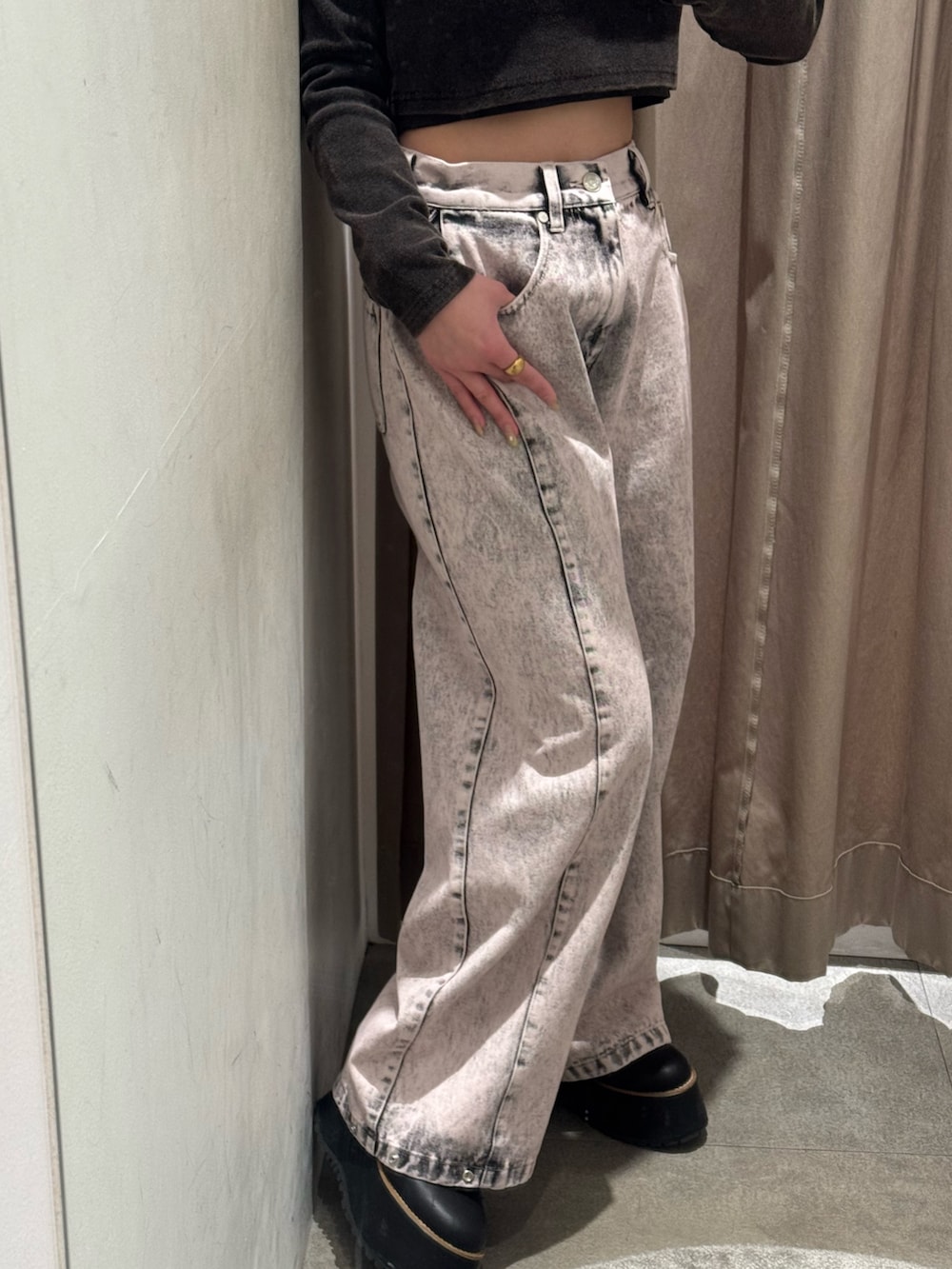 ピンク系のデニムパンツ、ブラック系のTシャツ/カットソー、ブラック系のブーツを着用したレディースの冬コーディネートの6枚目の写真
