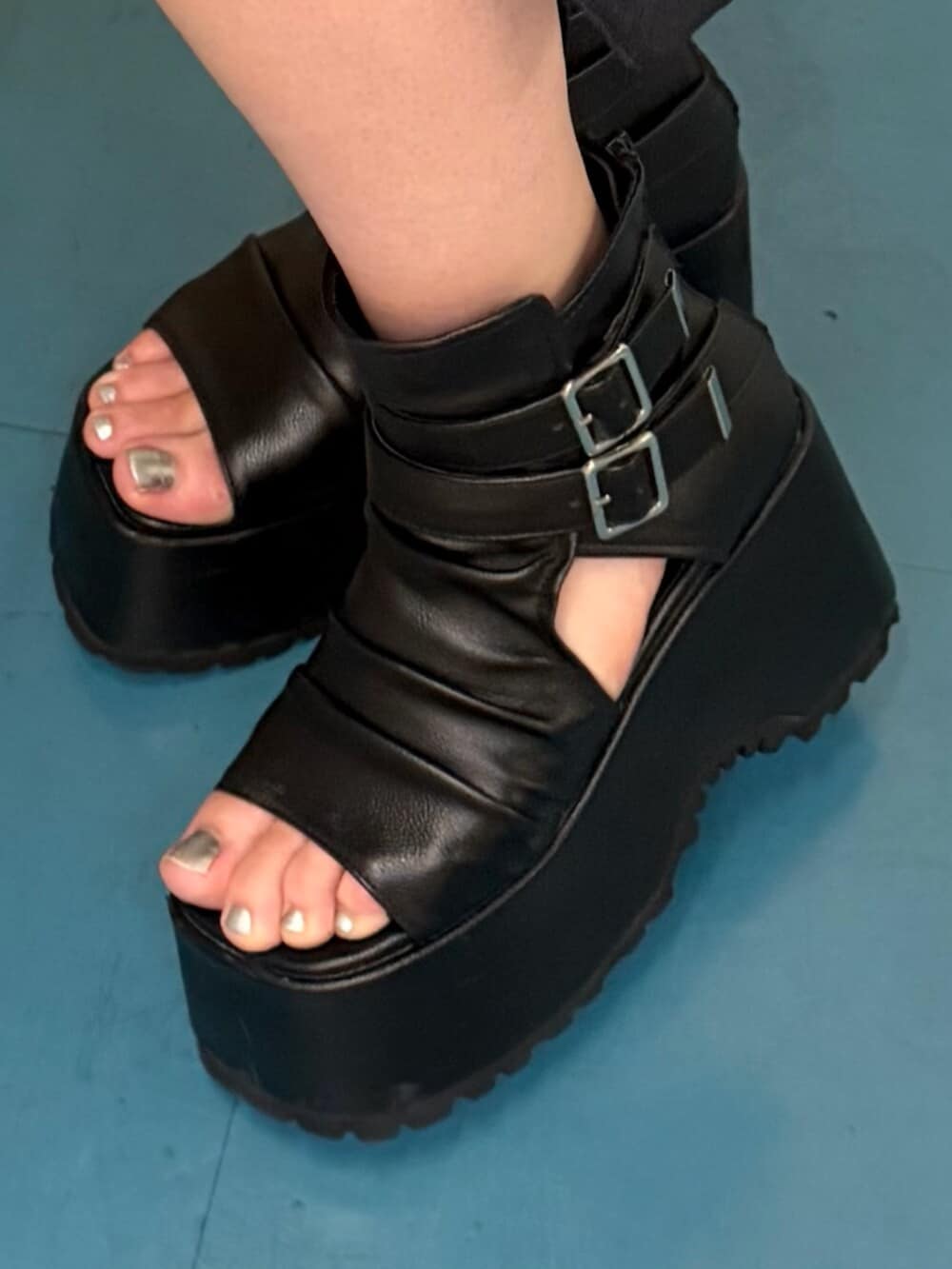 グレー系のデニムパンツ、ブラック系のブーツ、ブラック系のアンサンブルを着用したレディースの秋コーディネートの5枚目の写真