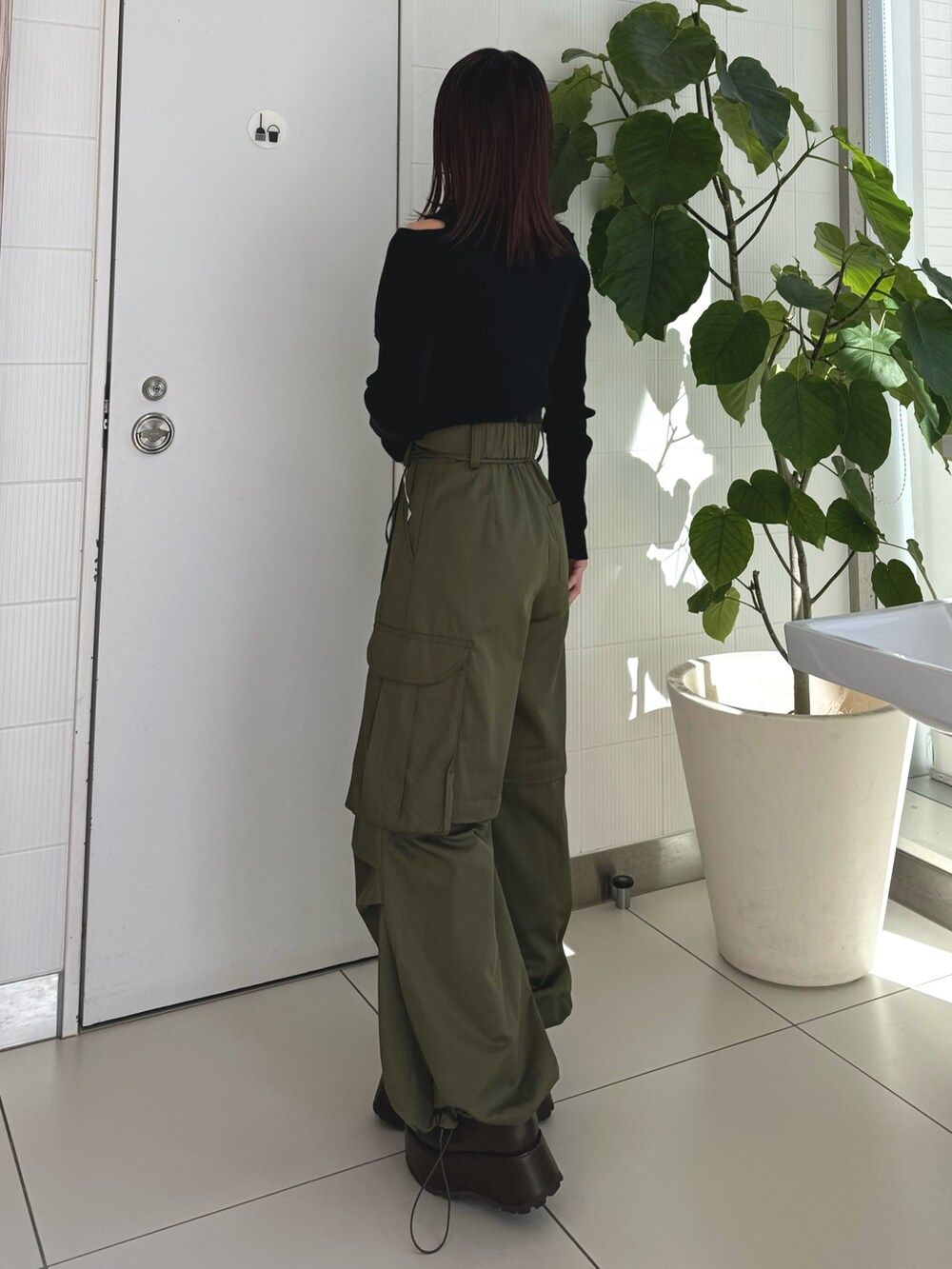 ブラック系のニット/セーター、ベージュ系のカーゴパンツ、ブラウン系のブーツを着用したレディースの秋コーディネートの3枚目の写真