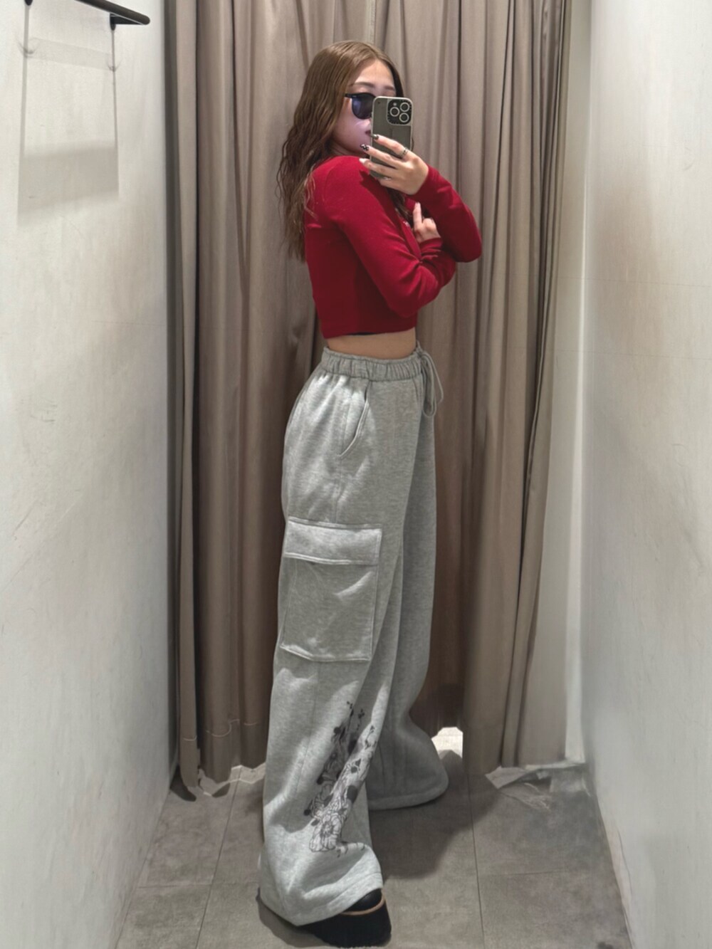 ブラック系のブーツ、グレー系のスウェットパンツ、レッド系のTシャツ/カットソーを着用したレディースの秋コーディネートの2枚目の写真