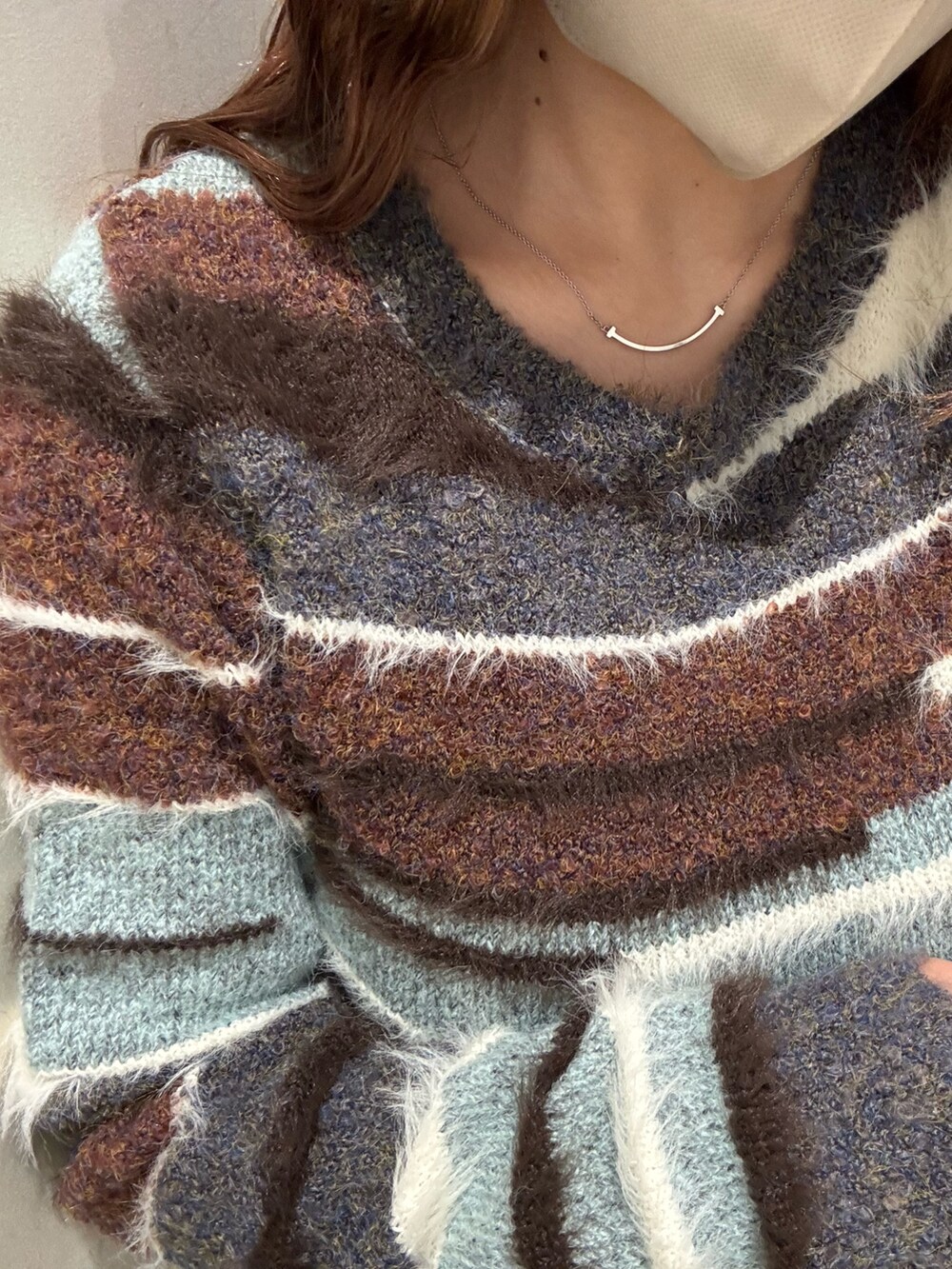 ブラウン系のデニムパンツ、ブラウン系のニット/セーター、ブラック系のブーツを着用したレディースの秋コーディネートの5枚目の写真