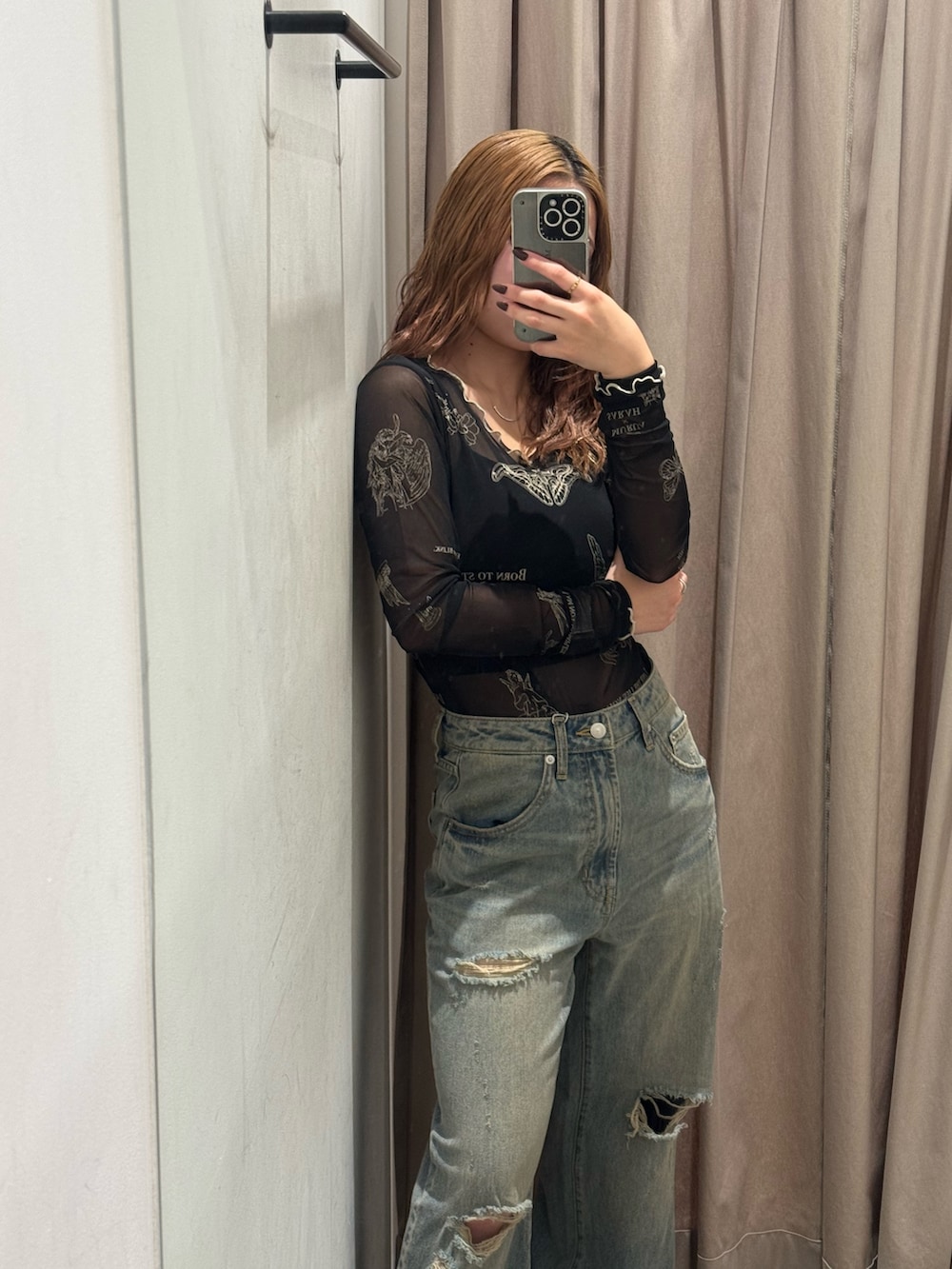 ブルー系のデニムパンツ、ブラック系のTシャツ/カットソー、ブラック系のブーツを着用したレディースの秋コーディネートの4枚目の写真