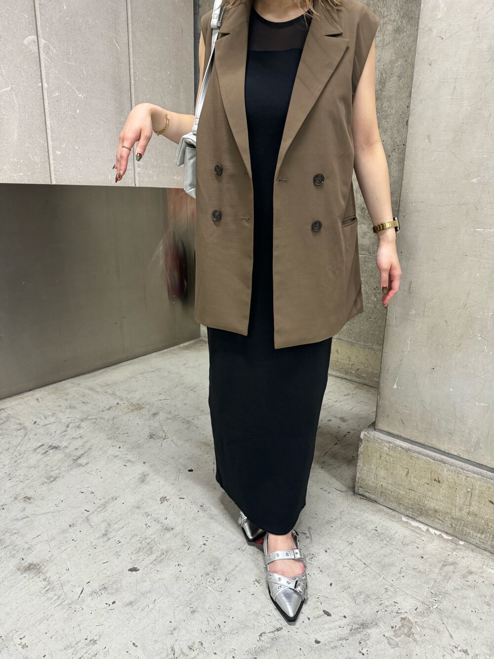 ブラウン系のベスト、ブラック系のワンピース、シルバー系のハンドバッグを着用したレディースの夏コーディネートの7枚目の写真