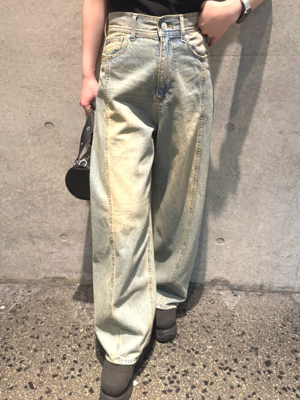 ブルー系のデニムパンツ、ブラック系のブーツ、ブラック系のニット/セーターを着用したレディースの春コーディネートの7枚目の写真