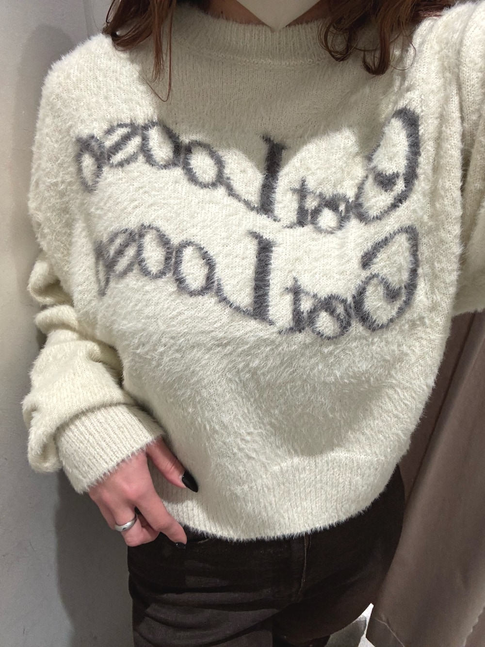 ホワイト系のニット/セーター、ブラウン系のデニムパンツ、ブラック系のブーツを着用したレディースの秋コーディネートの5枚目の写真