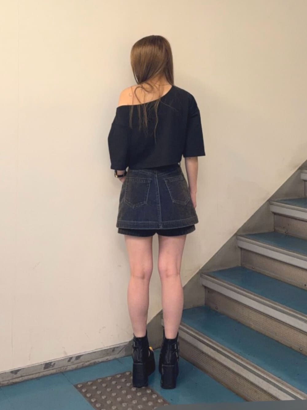 ブラック系のブーツ、ブラック系のTシャツ/カットソー、グリーン系のデニムスカートを着用したレディースの夏コーディネートの3枚目の写真