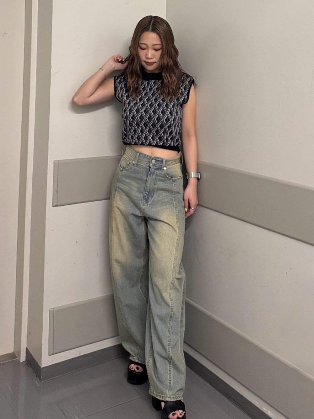 ブルー系のデニムパンツ、ブラック系のタンクトップ、ブラック系のサンダルを着用したレディースの夏コーディネートの5枚目の写真