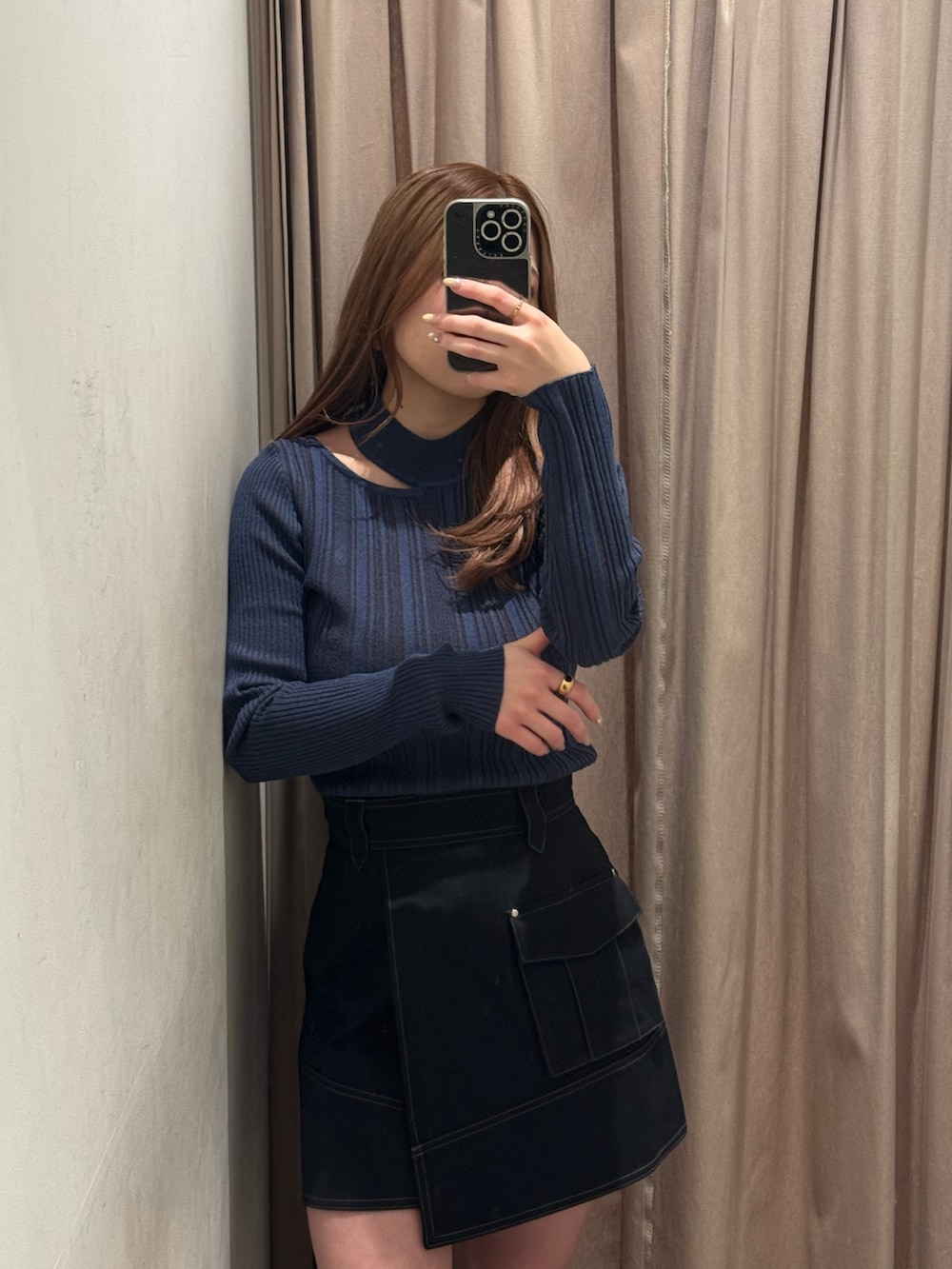 ブラック系のスカート、ブルー系のニット/セーター、ブラック系のブーツを着用したレディースの冬コーディネートの4枚目の写真